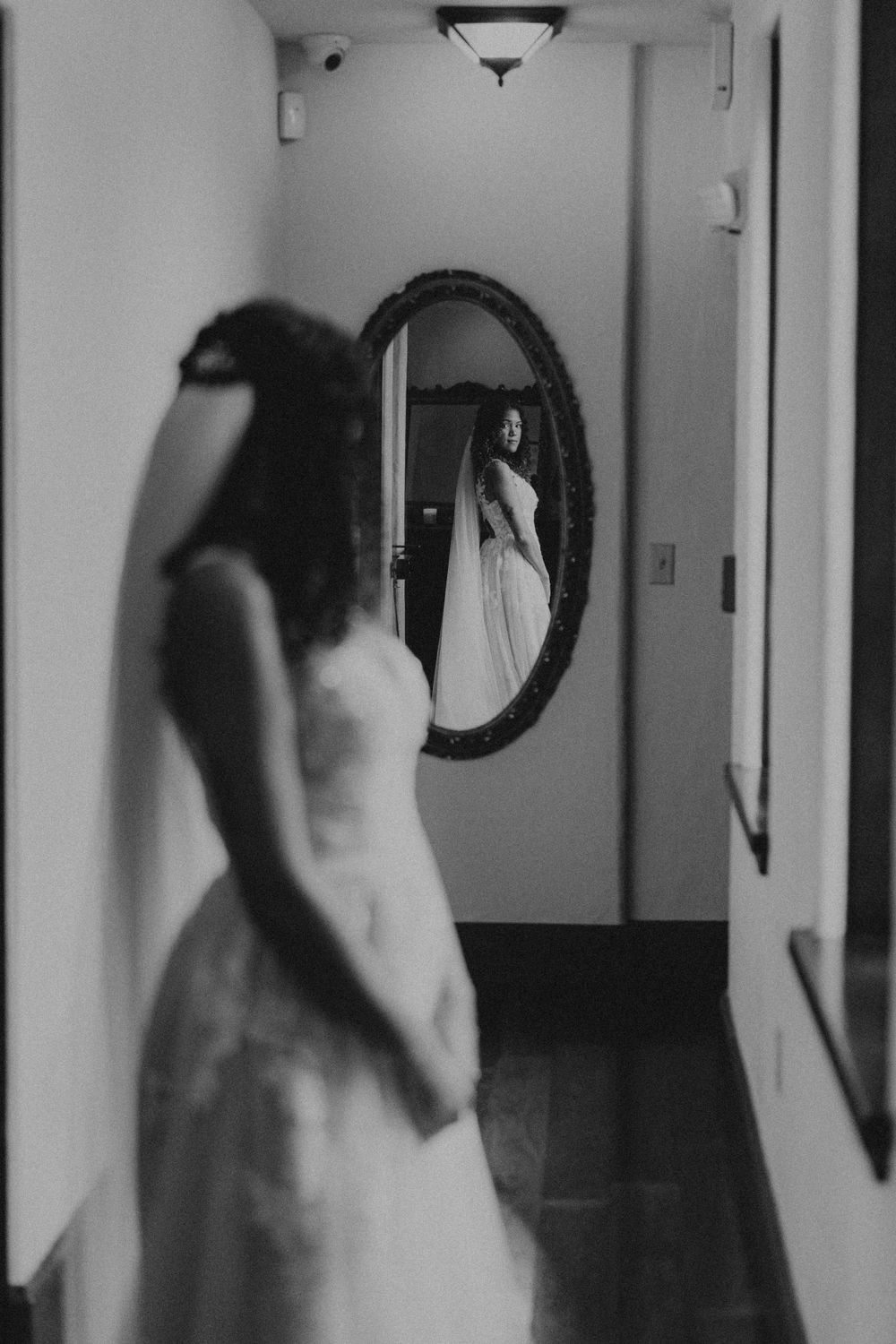 Black and white image showing blurred movement in hallway with mirror.
