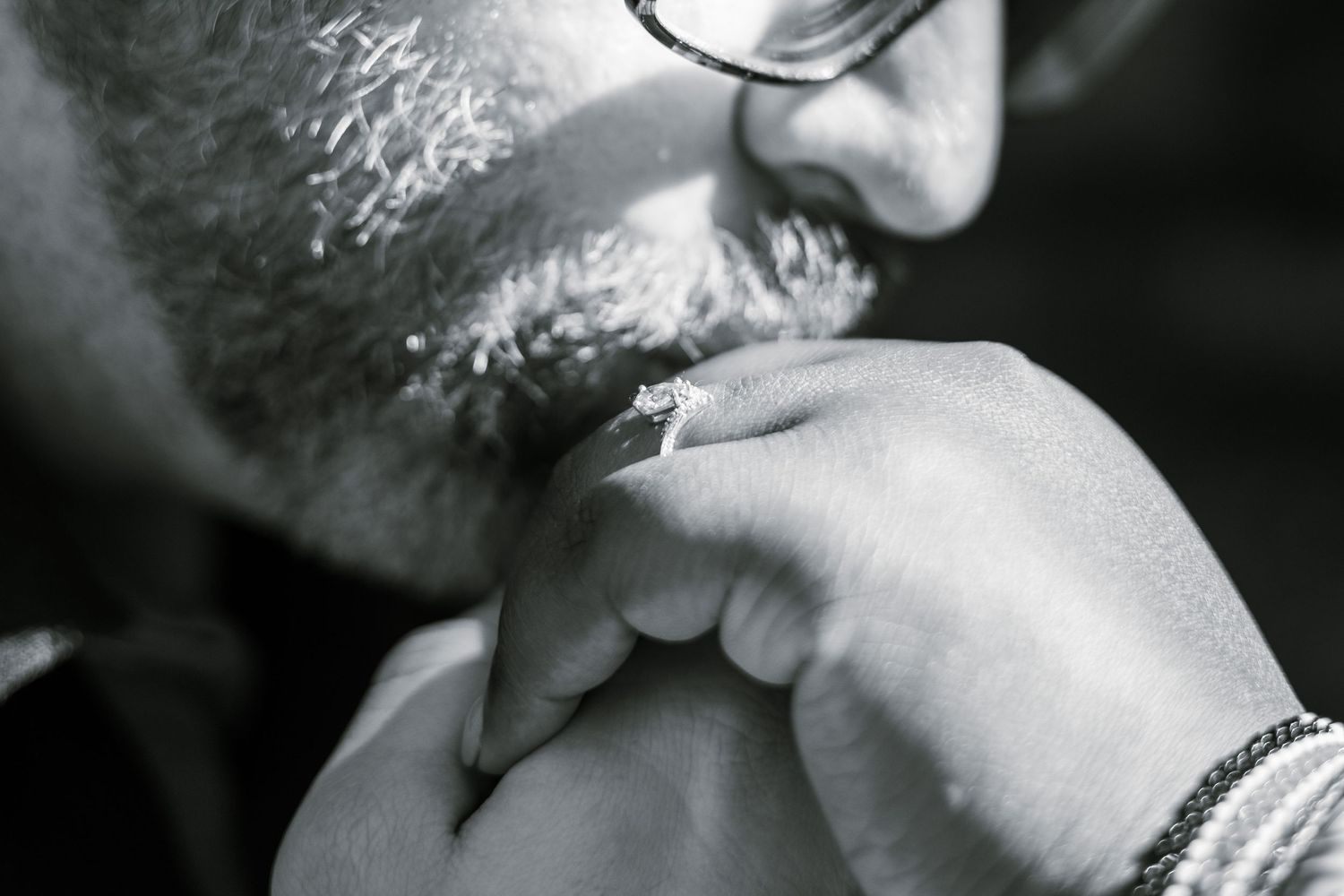 Groom kissing bride's diamond engagement ring photography
