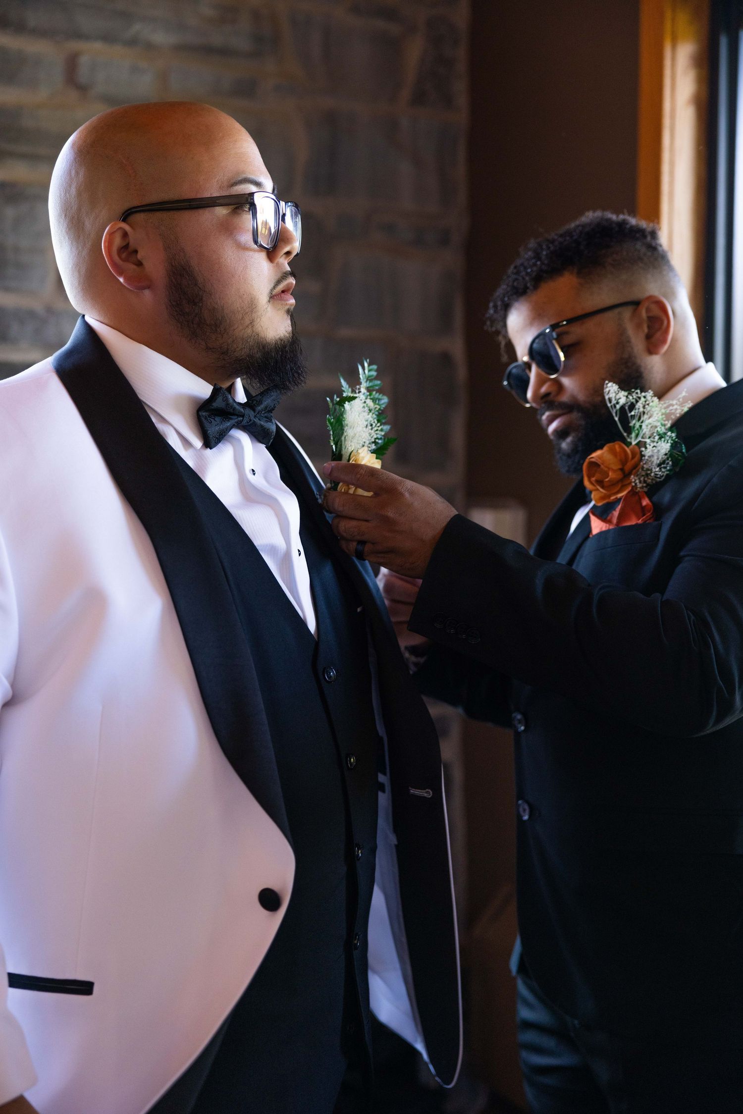 Groomsman pinning boutonniere on groom photography