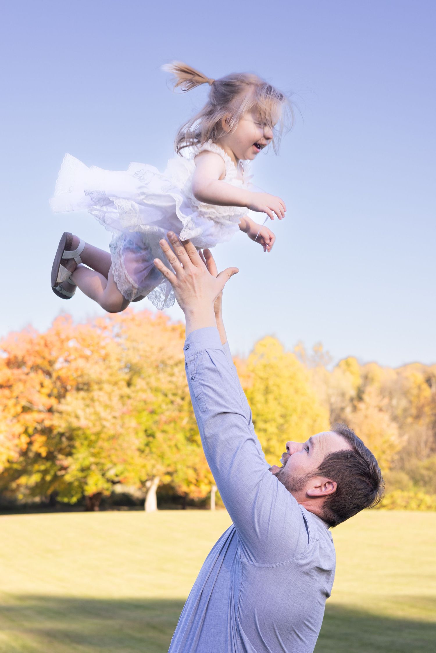 Dad tossing daughter in air photography