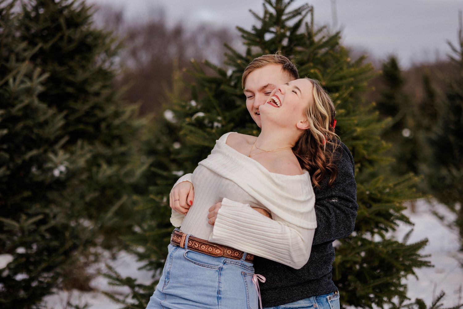 Couple laughing Christmas tree farm photography