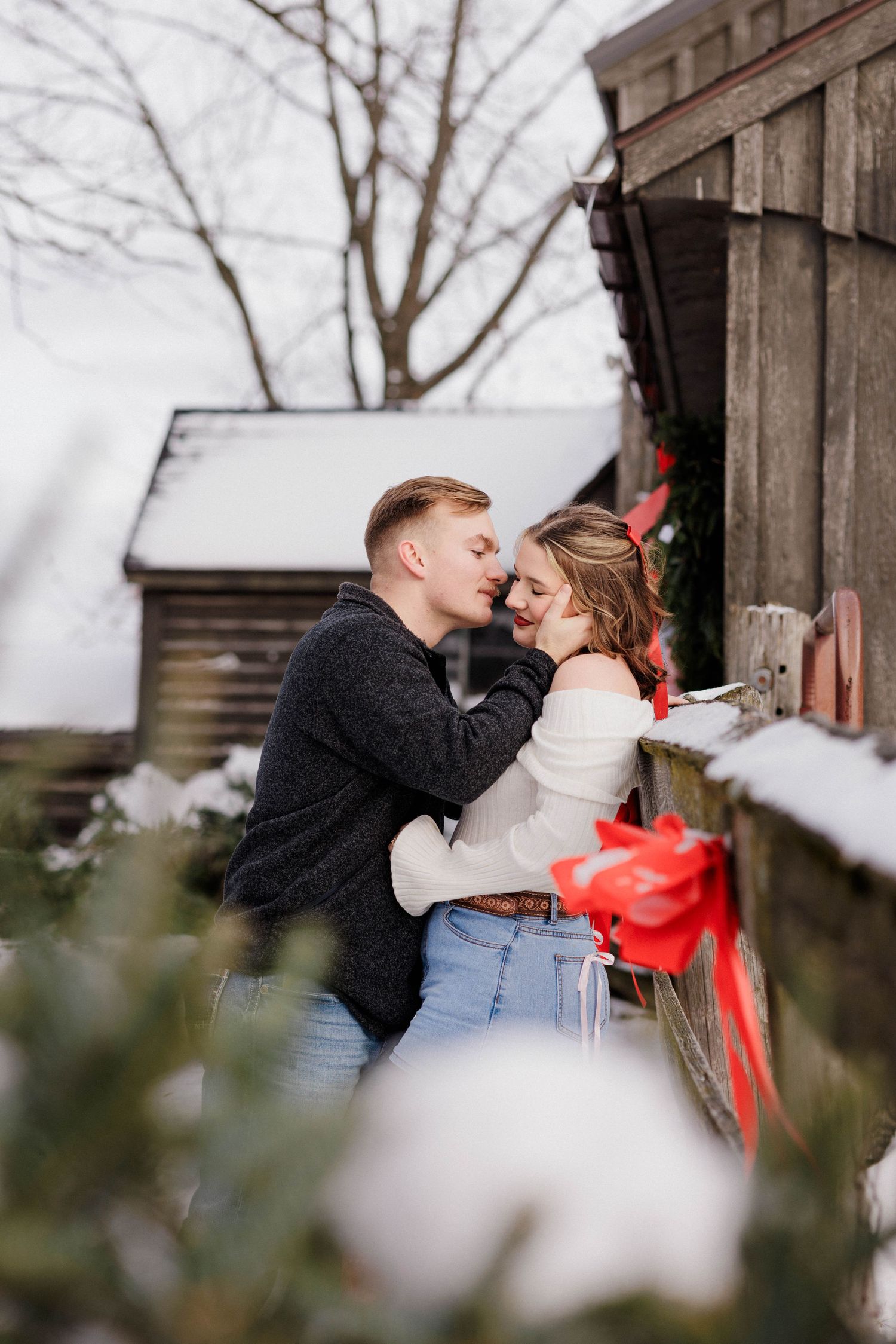 Couple almost kissing snowy barn photography