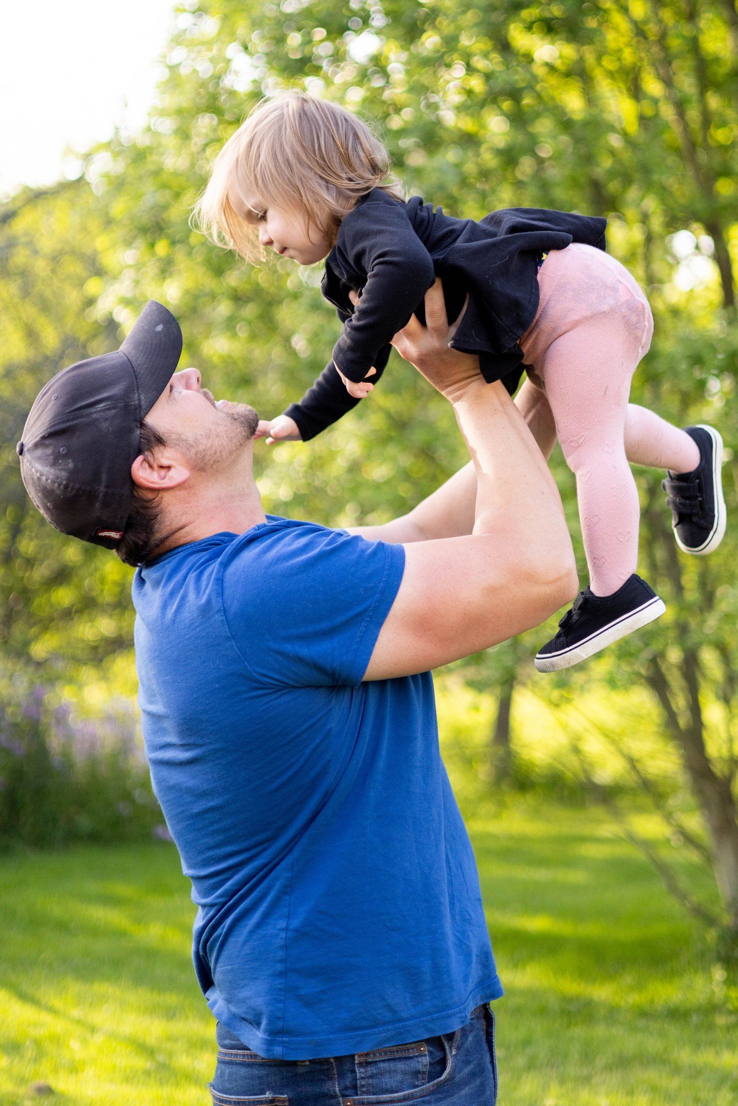 Father lifting toddler daughter outdoors photography
