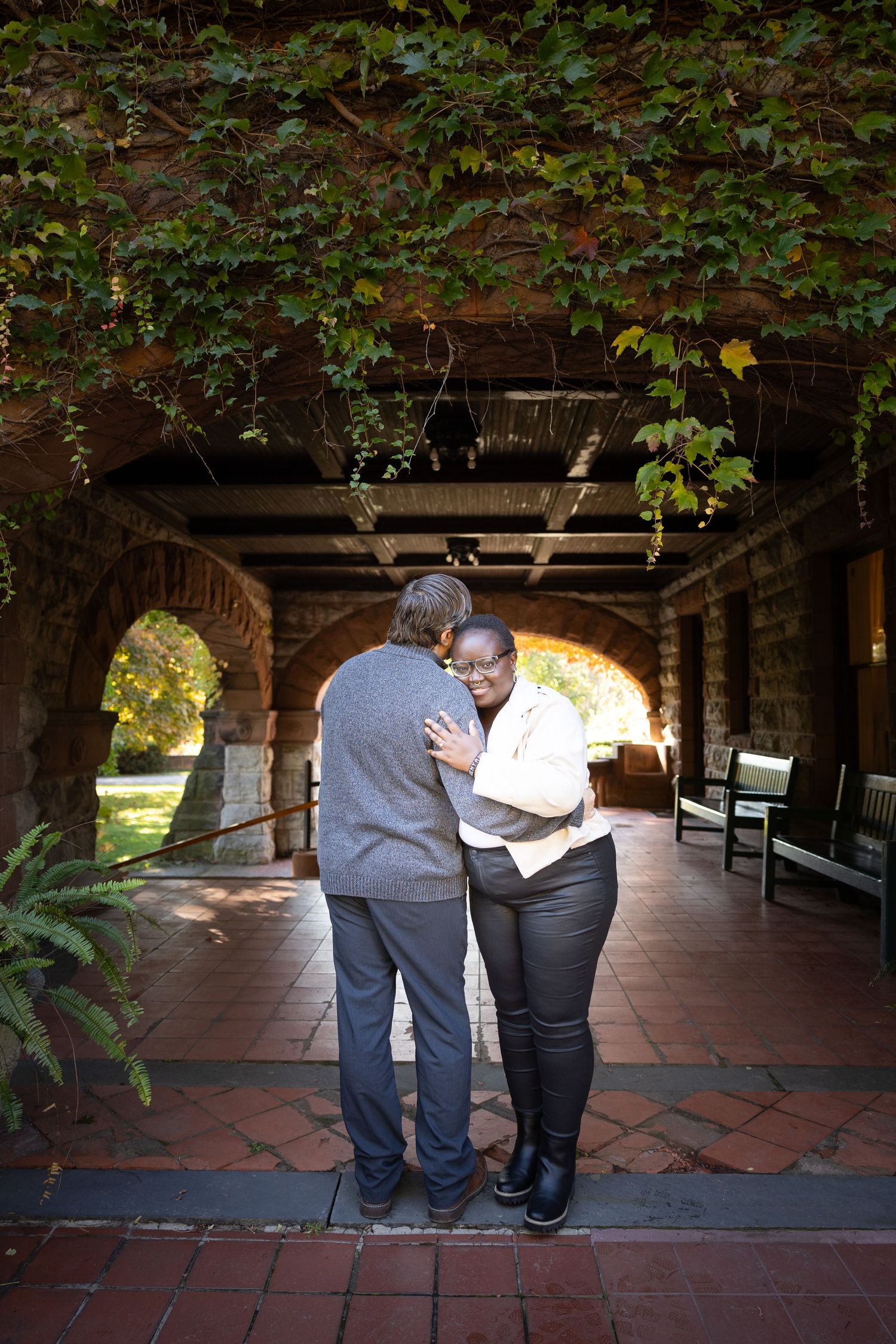 Couple embracing under ivy archway photography