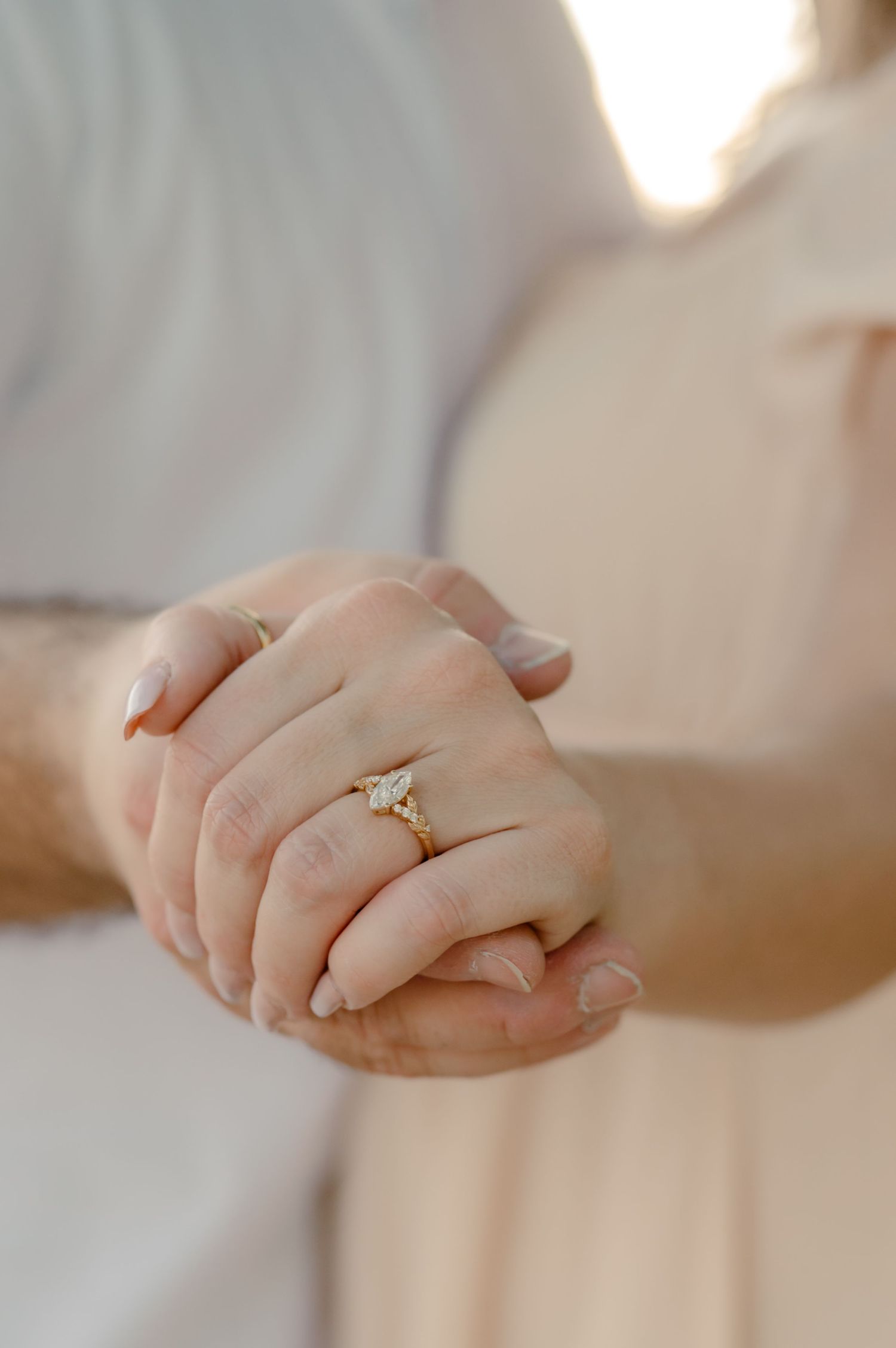 Close-up shots of hands wearing engagement rings in soft natural lighting.