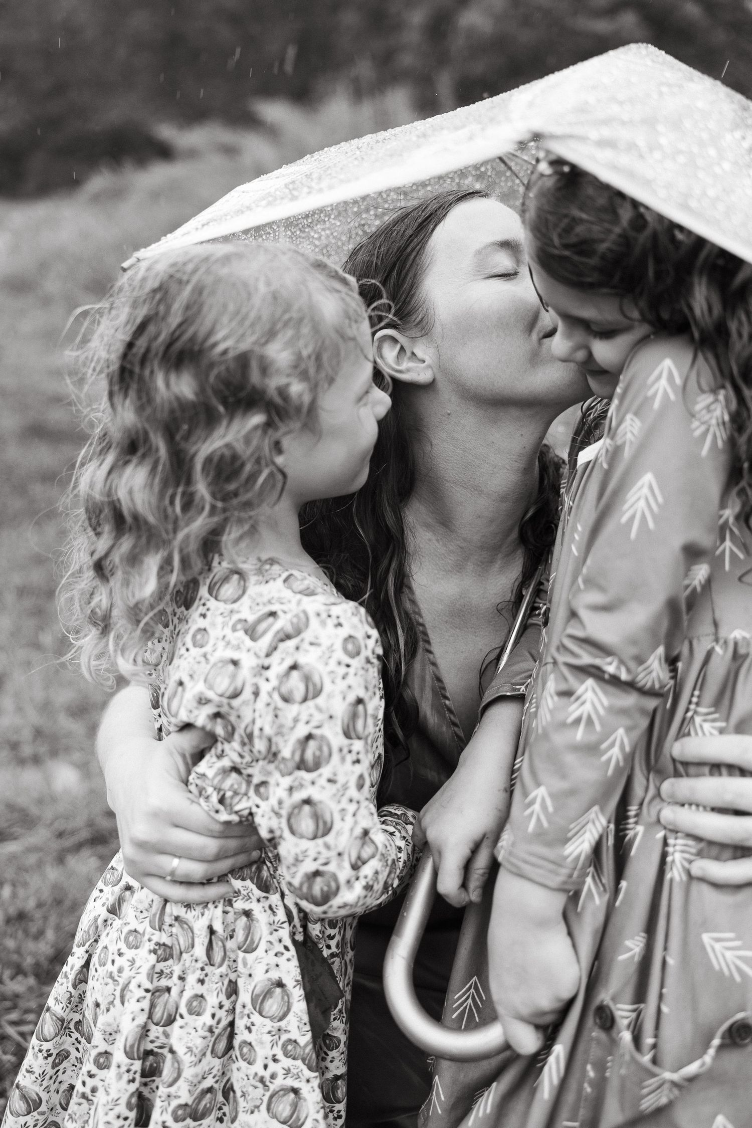 Black and white sequence of romantic poses under an umbrella in nature.