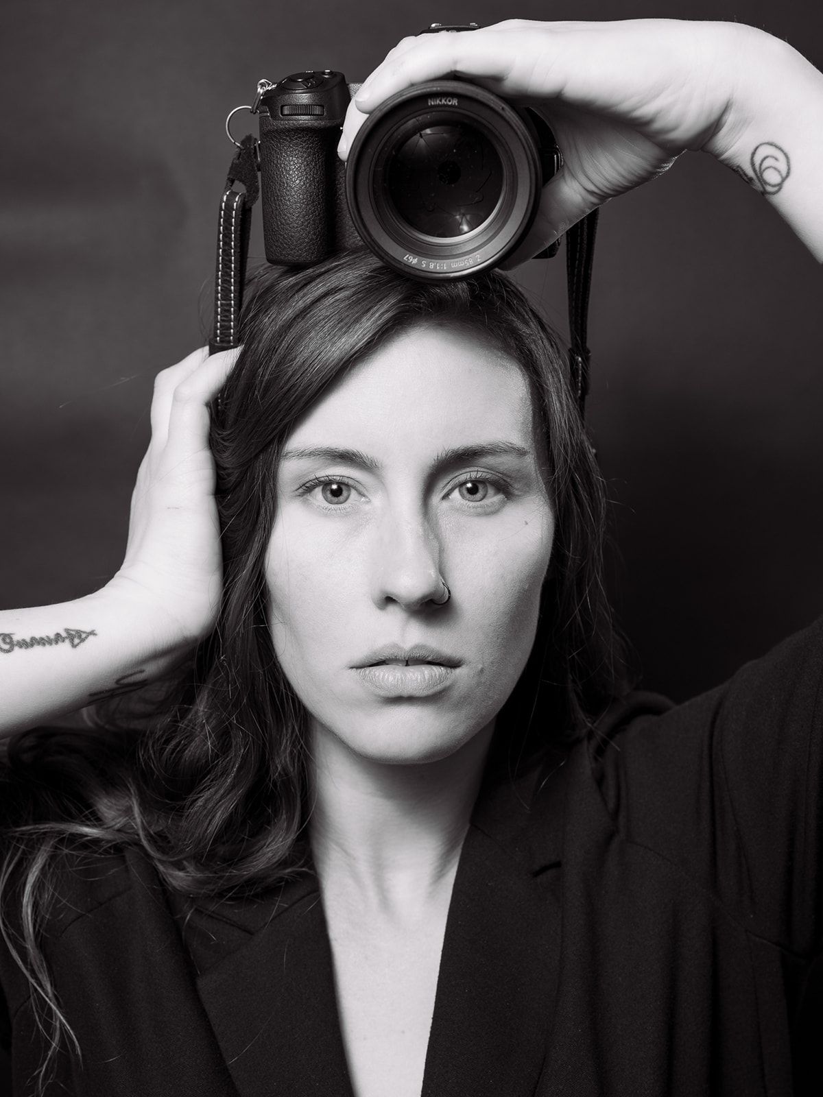 Black and white portrait series showing Jessica Sagerty holding a camera against dark background.