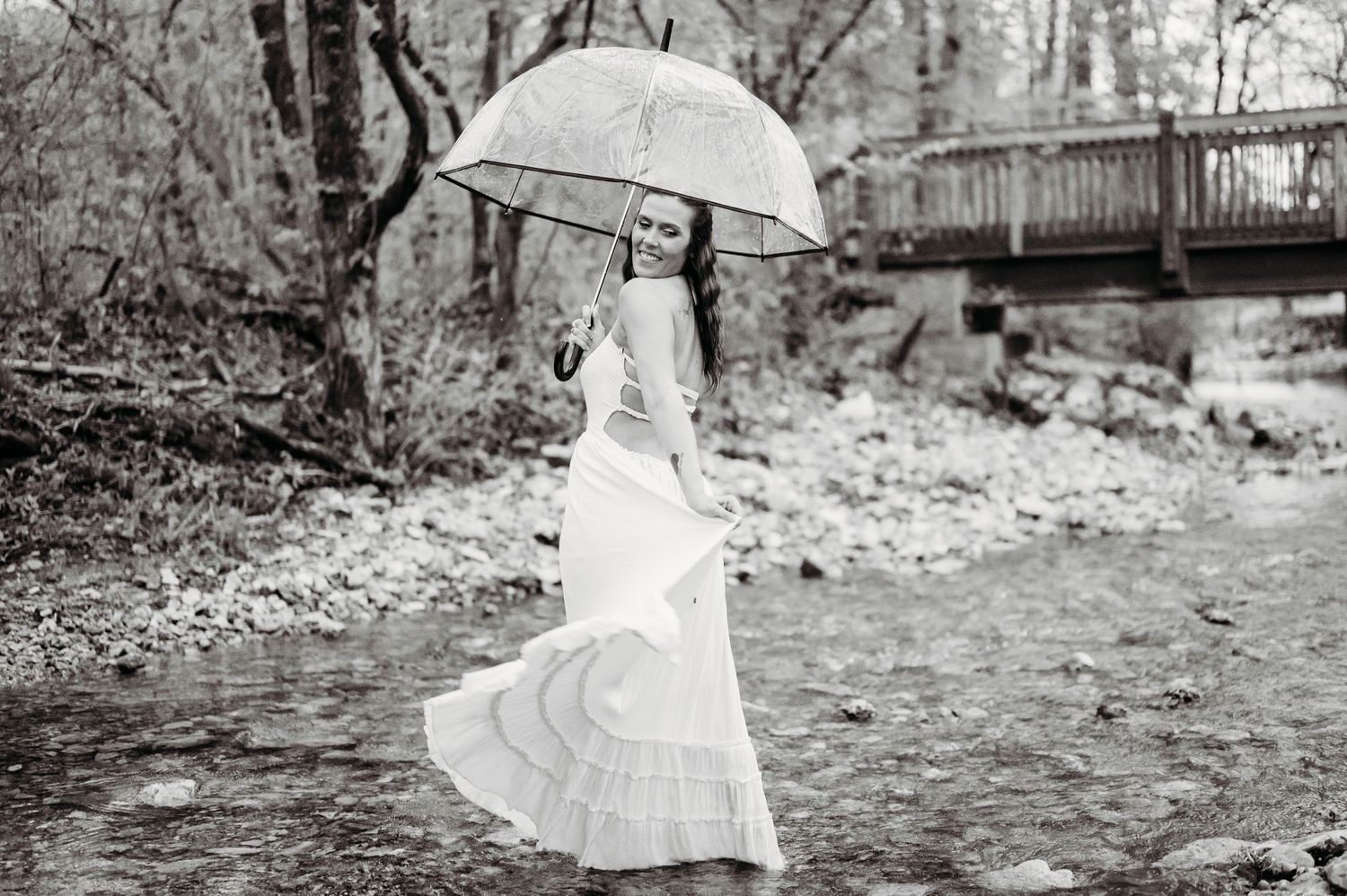A series of black and white photos showing a person in a white dress and umbrella walking through a garden setting.