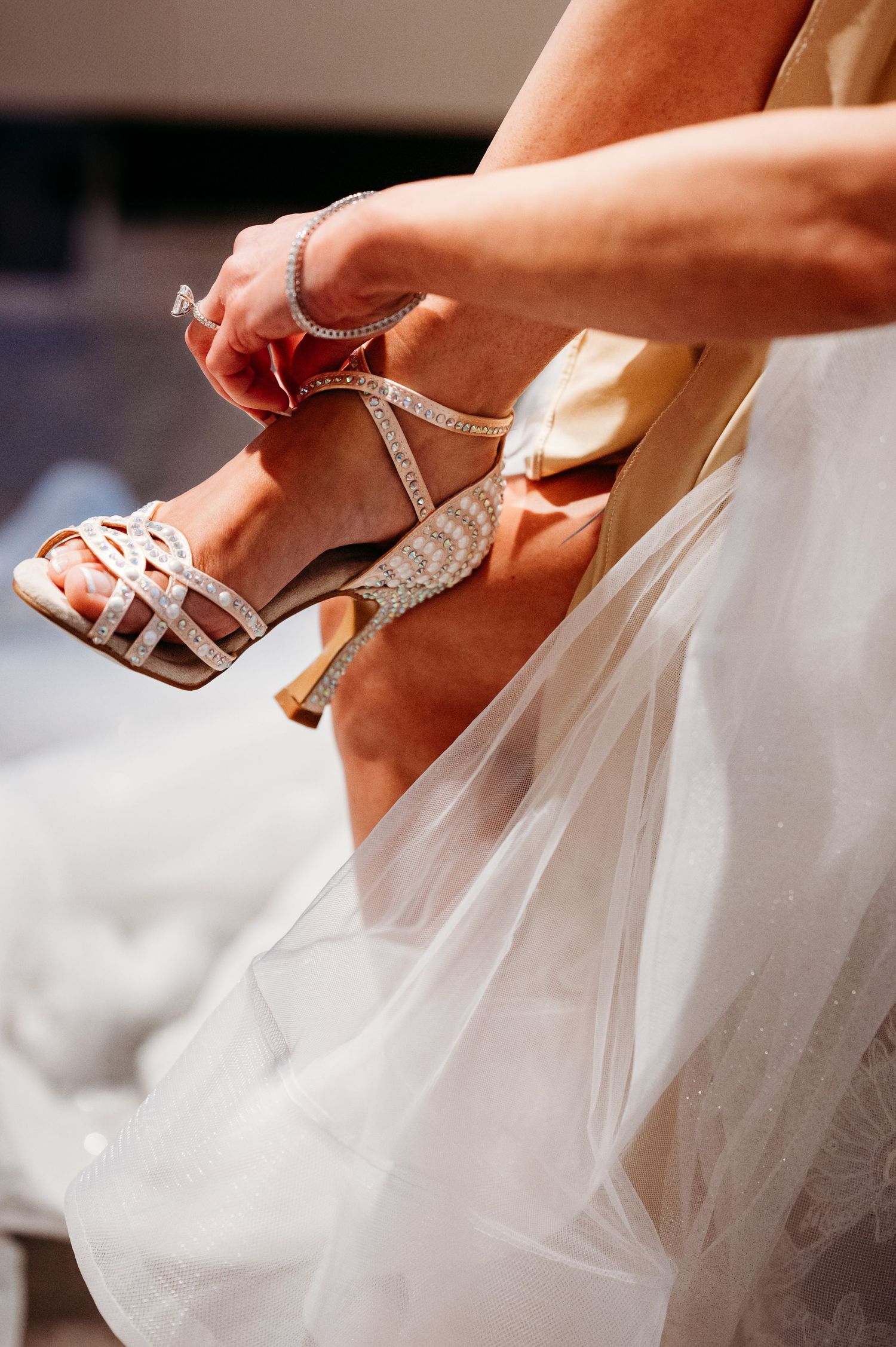 Series showing hands putting on glittery silver wedding shoes.