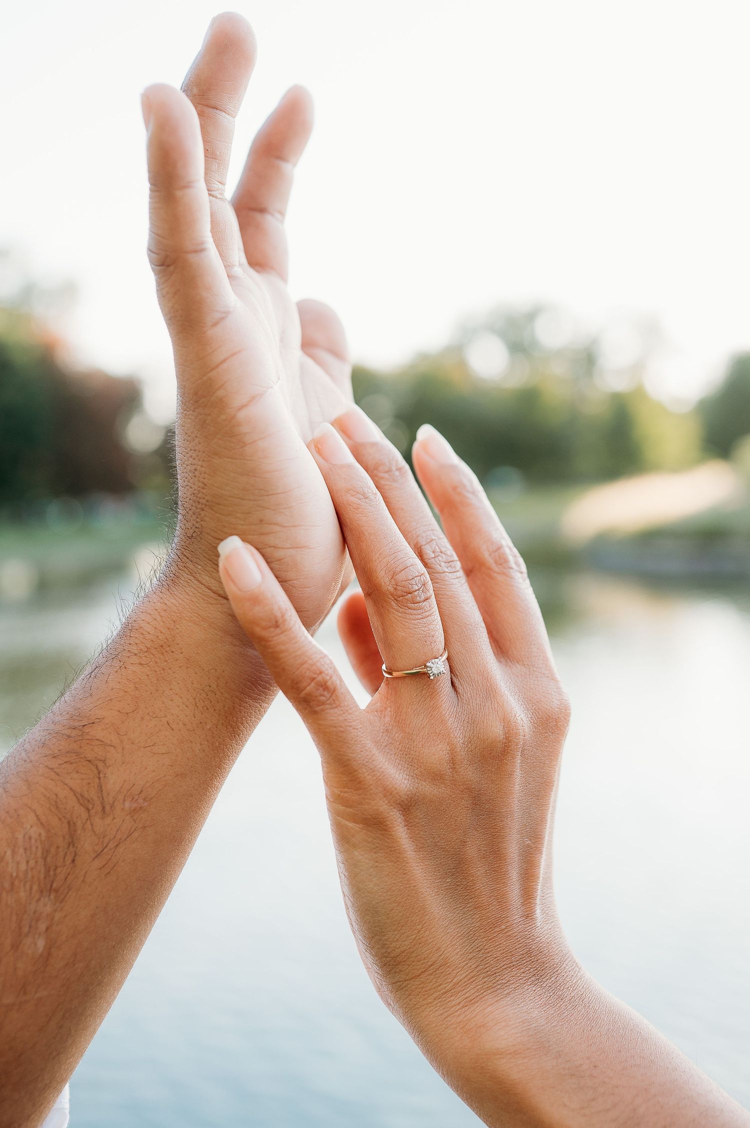 Close-up shots of hands showing off an engagement ring against a blurred outdoor background.