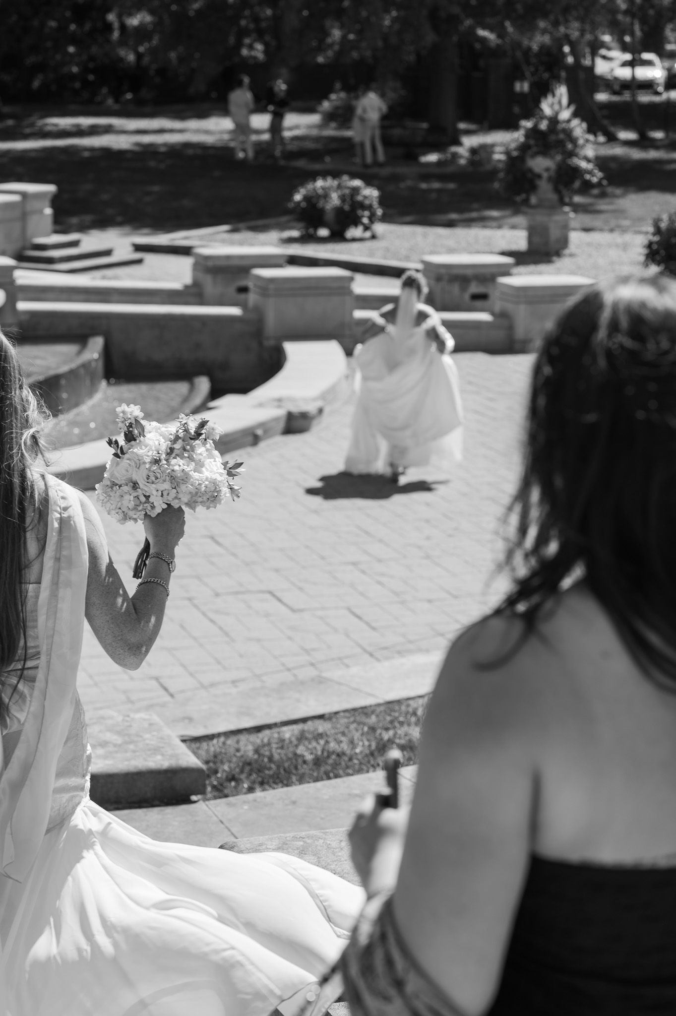 Black and white wedding photo of people gathered on outdoor stone patio.