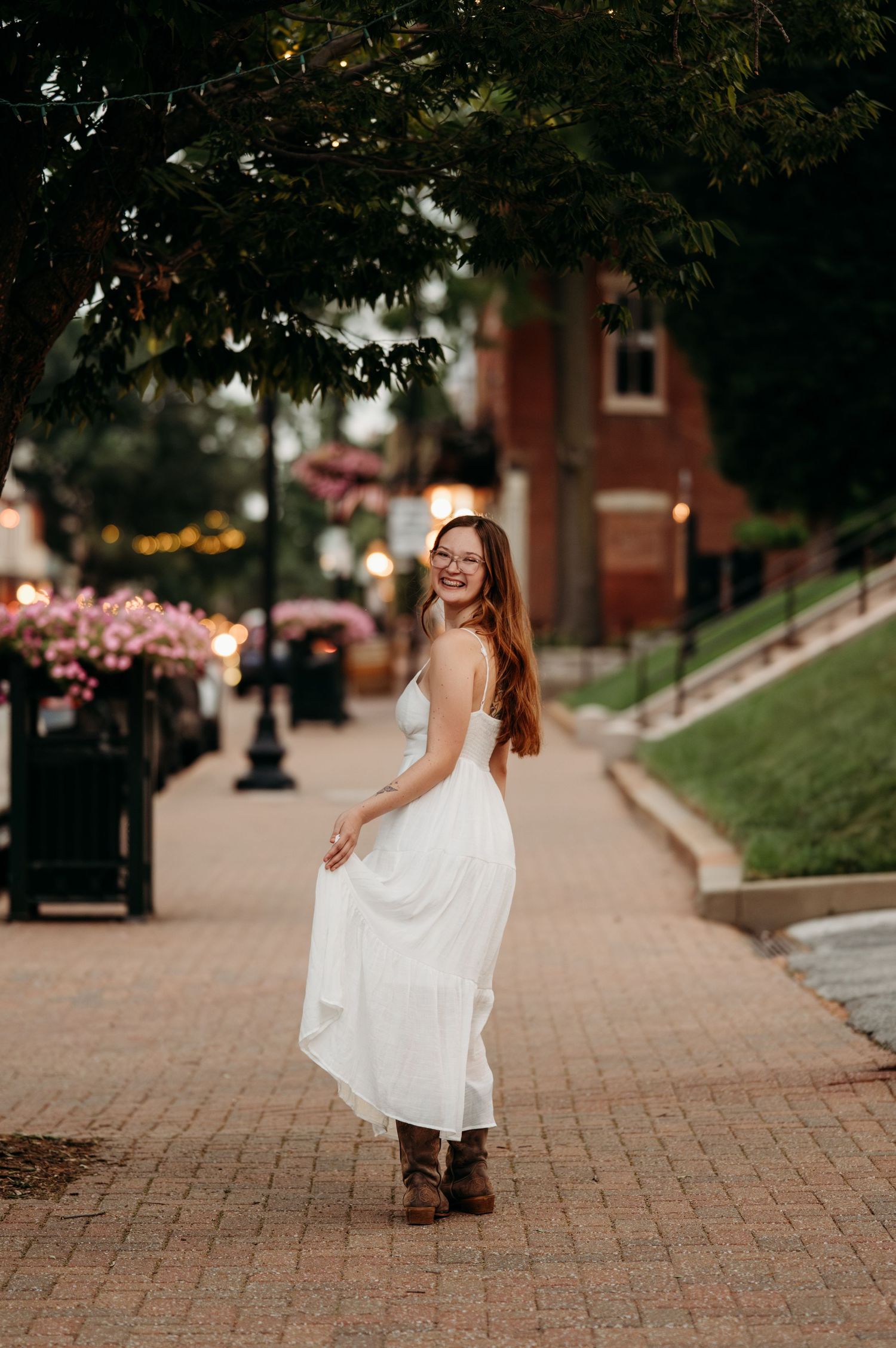 A sequence of photos showing a person in a flowing white dress twirling and dancing on a brick pathway.