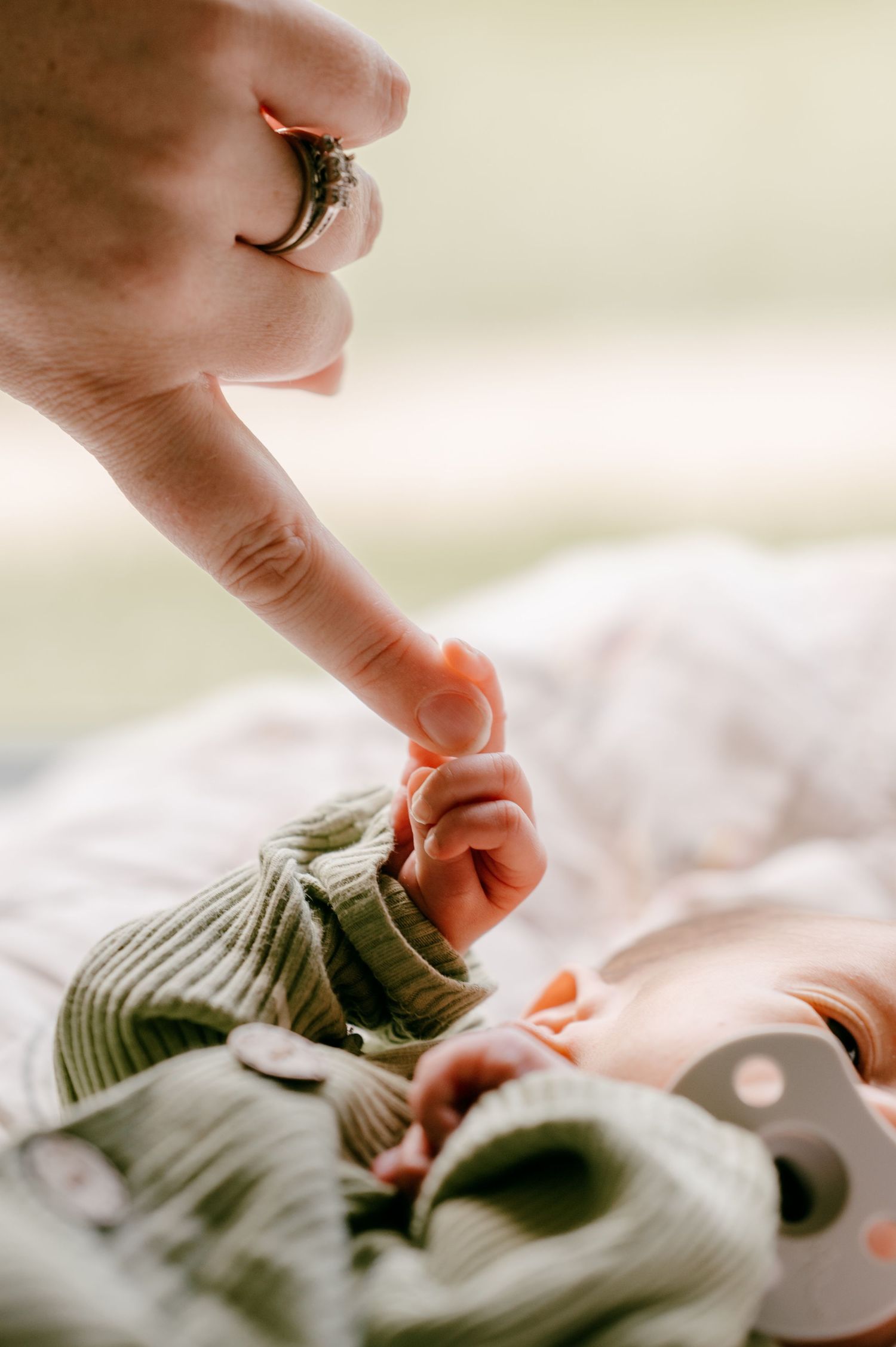 Close-up of tiny fingers reaching out during an intimate newborn photography session.