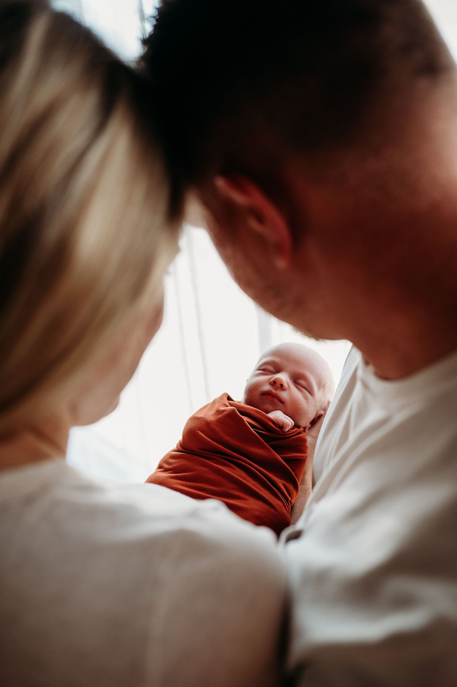 Intimate close-up portraits of newborn baby in natural window light.