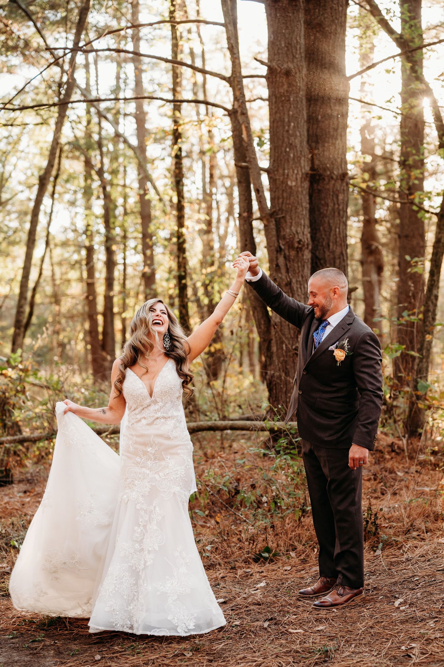 Joyful wedding portraits in a wooded forest setting with dramatic dress twirls.