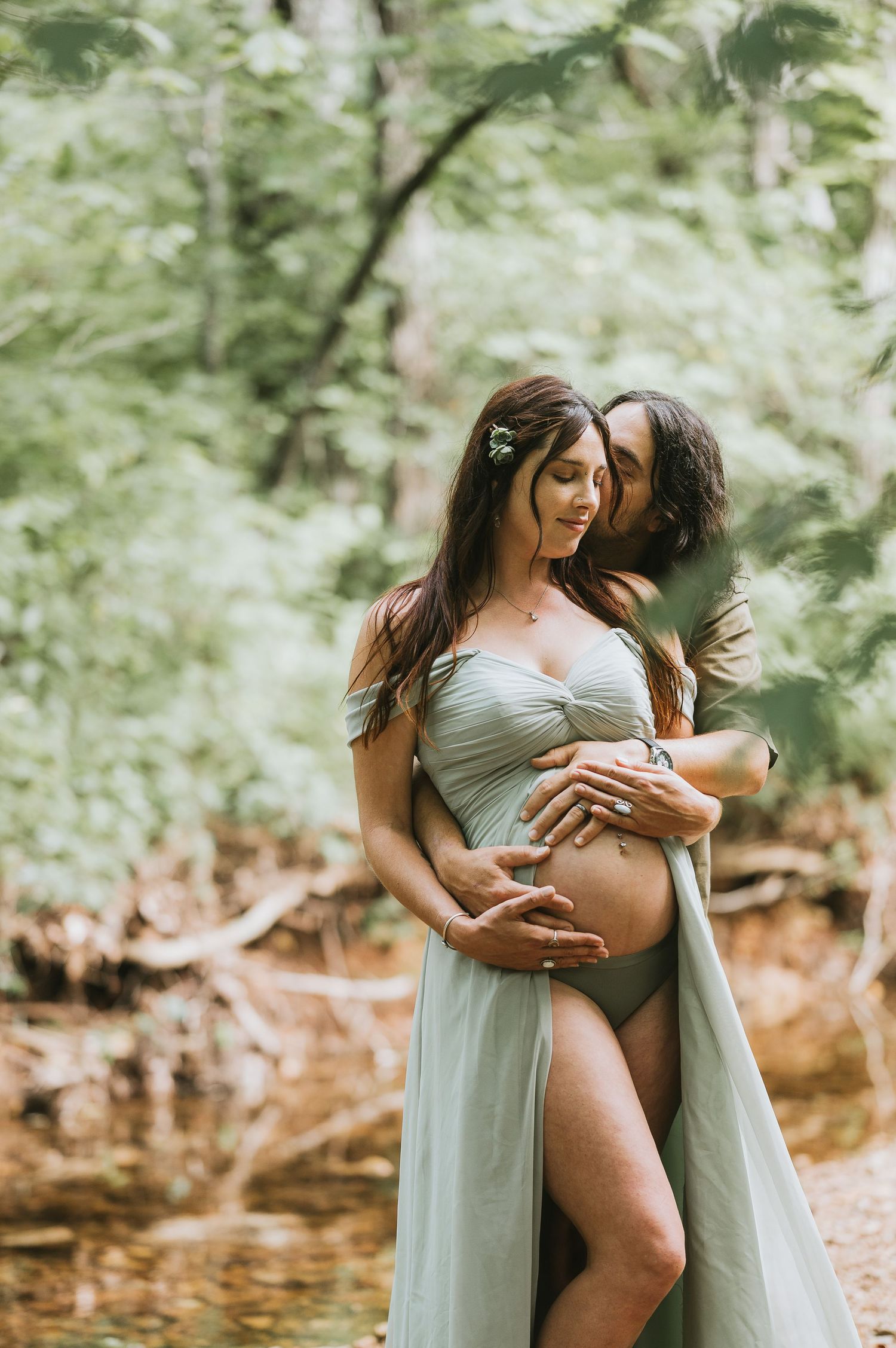 Intimate maternity photoshoot showing figure silhouettes in soft lighting among trees in Farmington, MO. Captured by Jessica Sagerty
