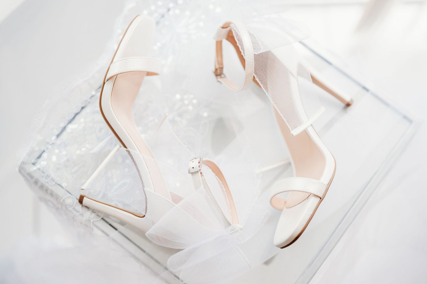 Elegant wedding rings displayed on white textured surfaces with soft lighting.