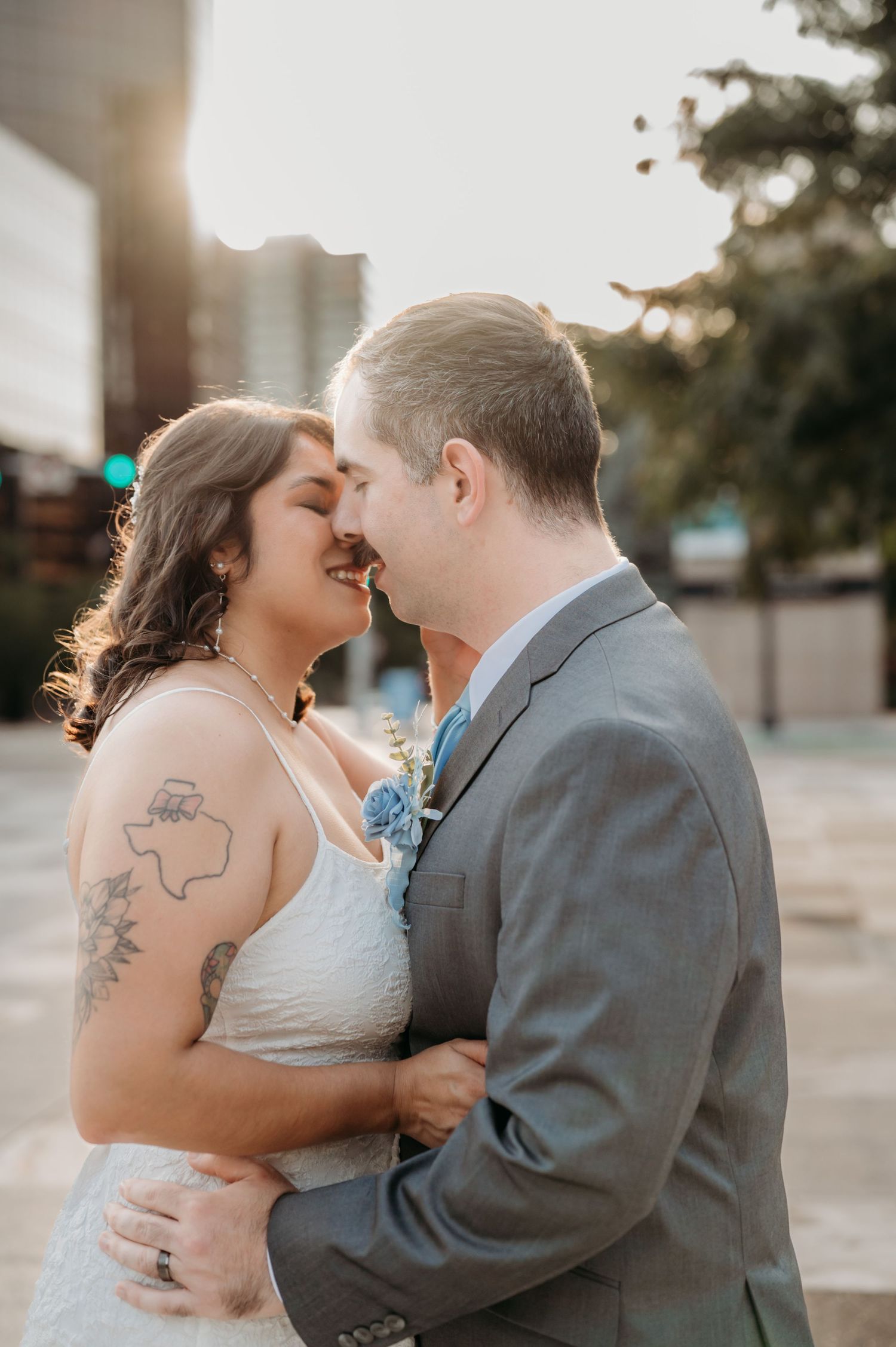 Intimate sunset portrait of newlyweds sharing tender moment outdoors.