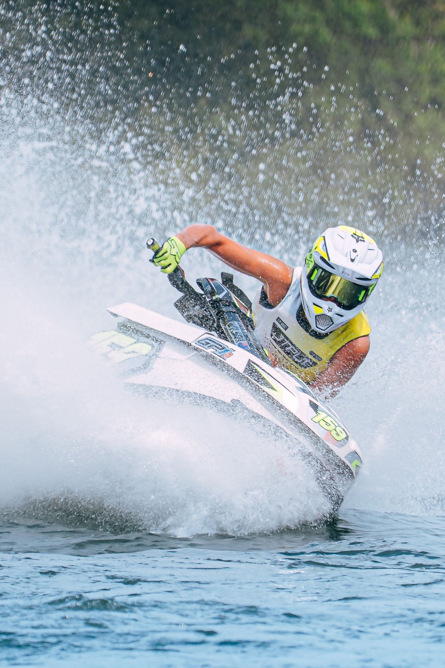 A sequence of action shots showing a jet ski rider performing a high-speed turn creating dramatic water spray on a blue lake.