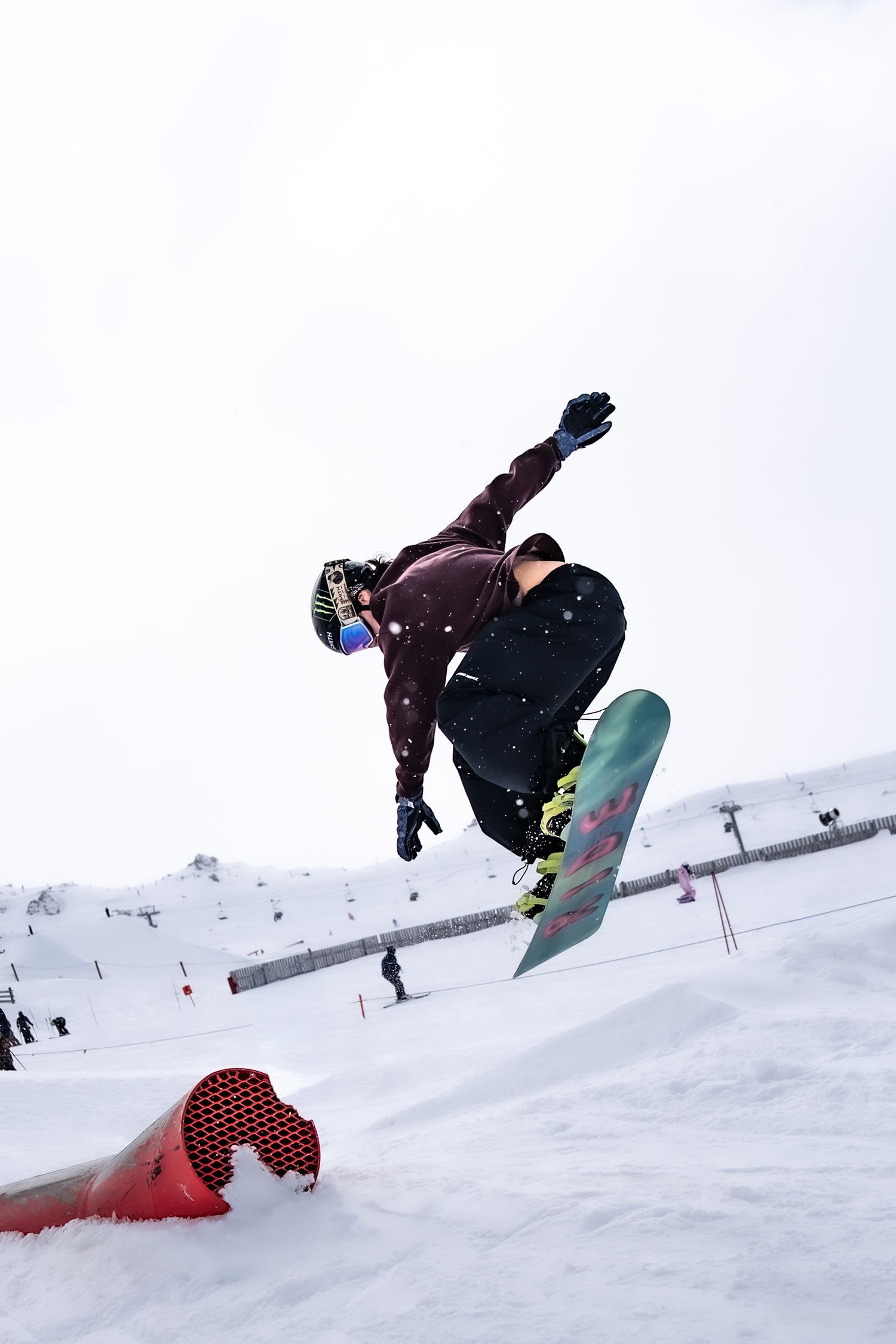 A sequence of four action shots showing a snowboarder performing aerial tricks and rotations on a snowy slope at Cardrona Alpine Report.