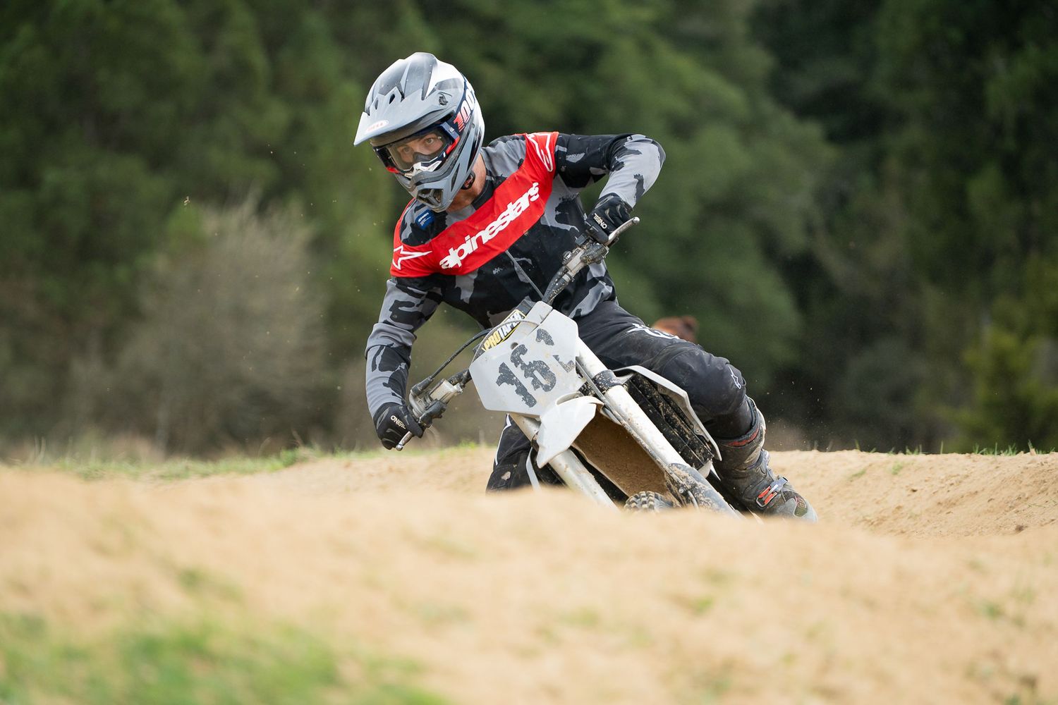 Motocross riders navigate challenging dirt track turns at high speed in the West Coast, South Island of New Zealand.