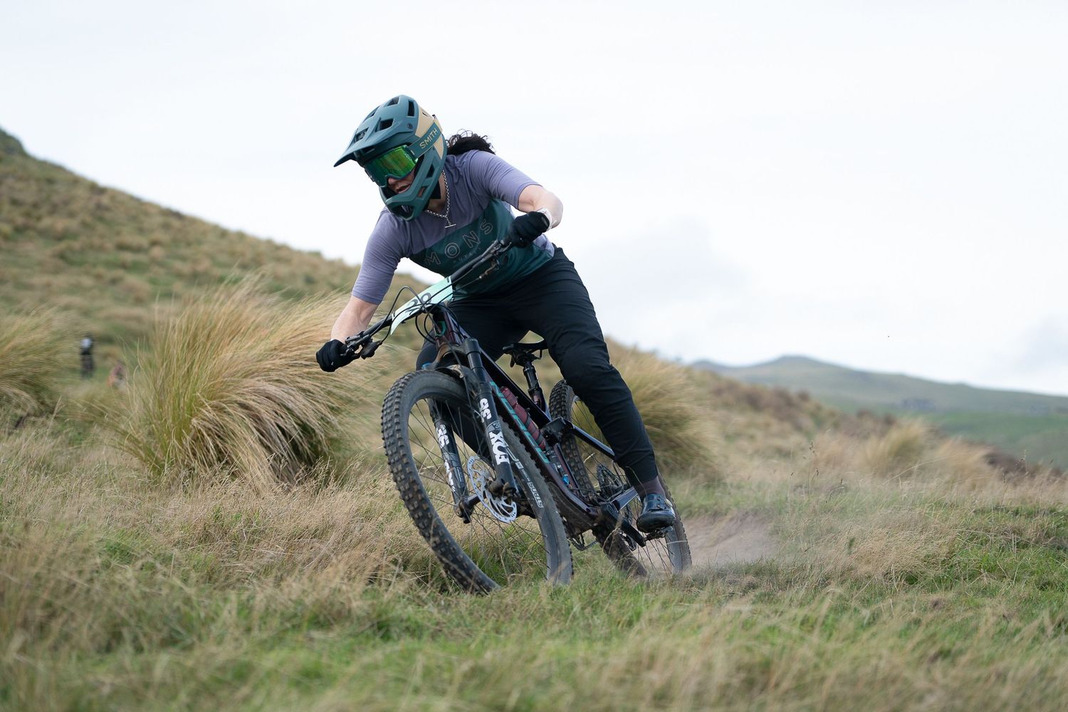 Mountain biker navigates steep terrain on a rugged hillside trail while wearing protective gear and helmet at the Crocodile MTB Bike Park.