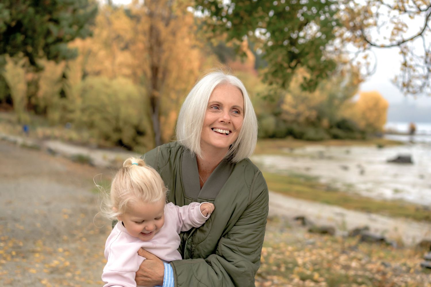 A series of outdoor family photos taken in autumn with fallen leaves and natural scenery along a waterfront path at Lake Wanaka.