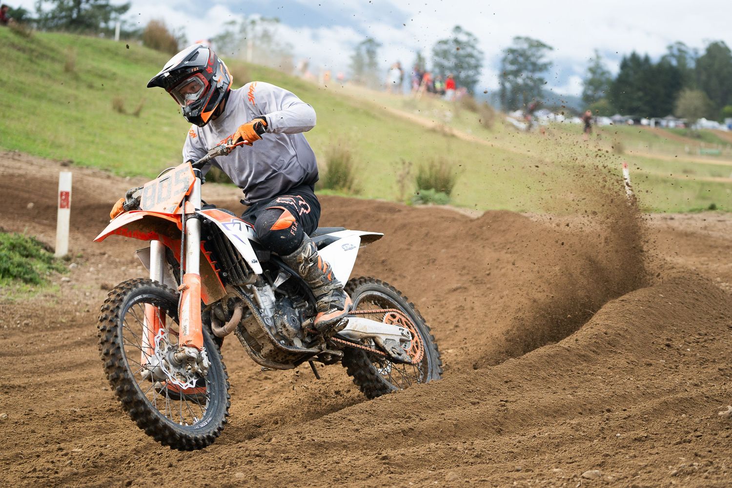 Dirt bike racing through muddy motocross track during competitive race event in the South Island of New Zealand.