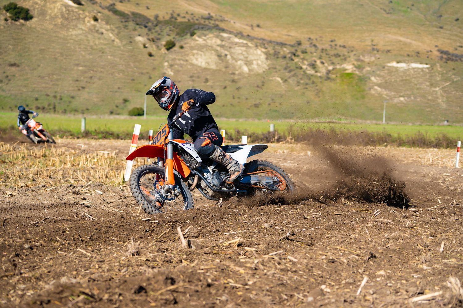 Dirt bike riders kick up dust while racing through challenging track terrain on a funday in North Canterbury.