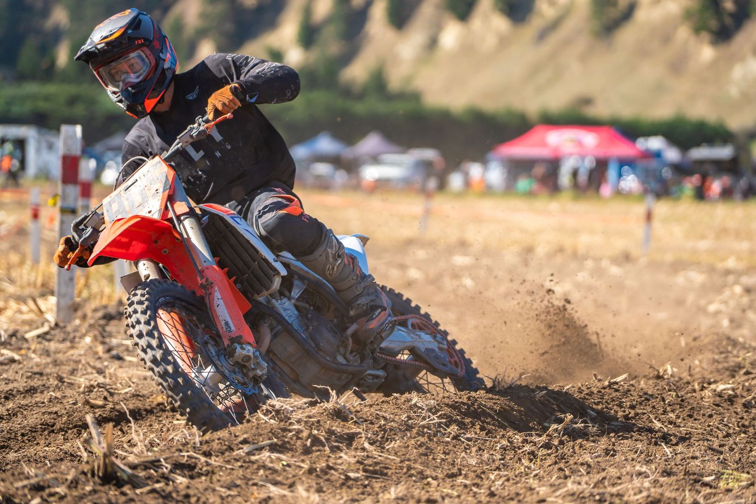 Dirt bike kicking up dust while racing through a motocross track during competition at a funday in North Canterbury.