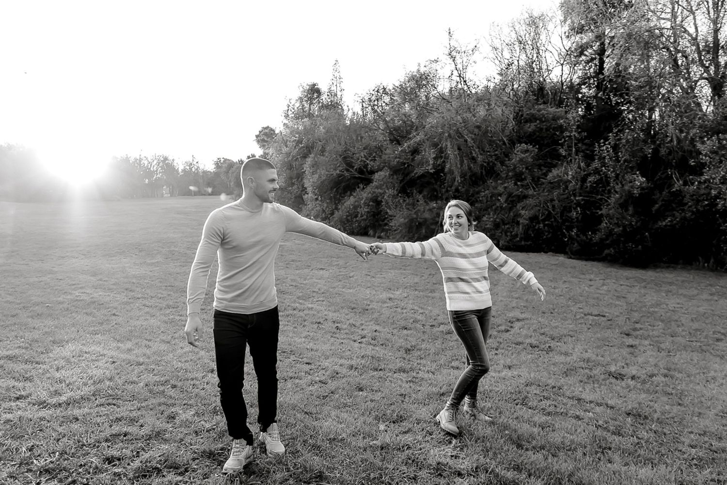 A black and white photo sequence showing two people playing soccer on a grassy hillside in foggy weather.