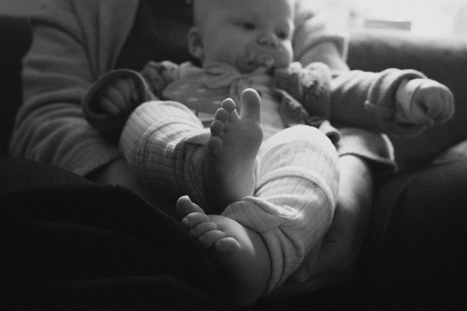 A black and white sequence of photos showing a baby sleeping peacefully in different positions.