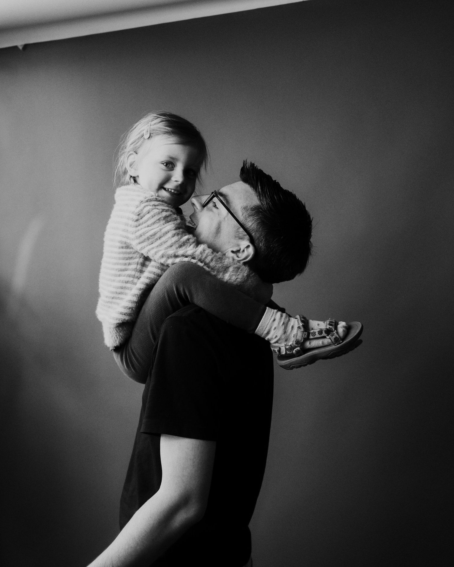 A series of black and white photographs showing an intimate embrace between two people in striped and dark clothing.