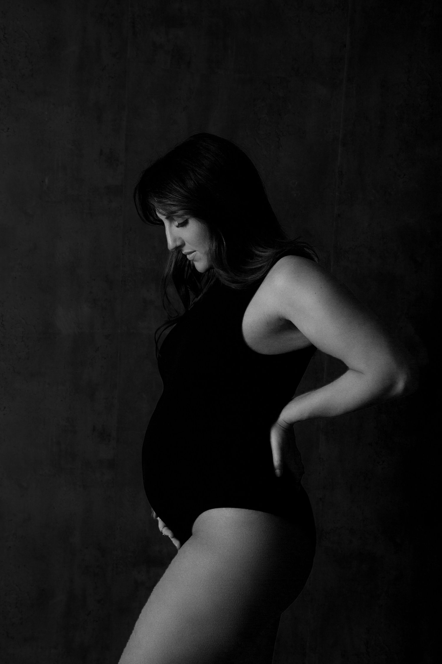 Artistic black and white portrait series showing silhouette of person in dramatic shadows against dark background.