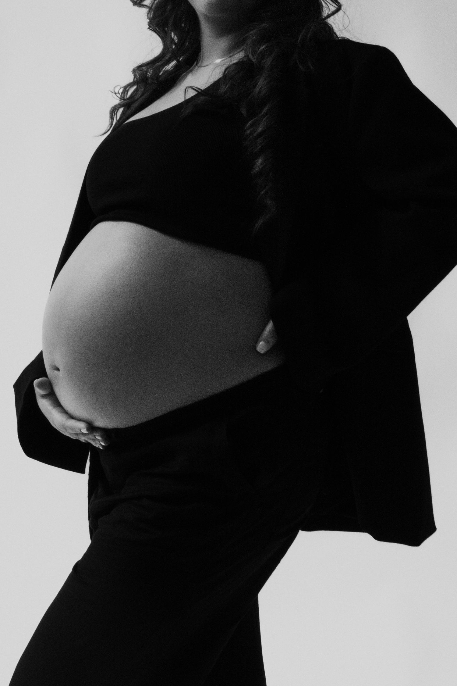 A black and white artistic portrait series showing a pregnant woman's silhouette in different poses against a light background.