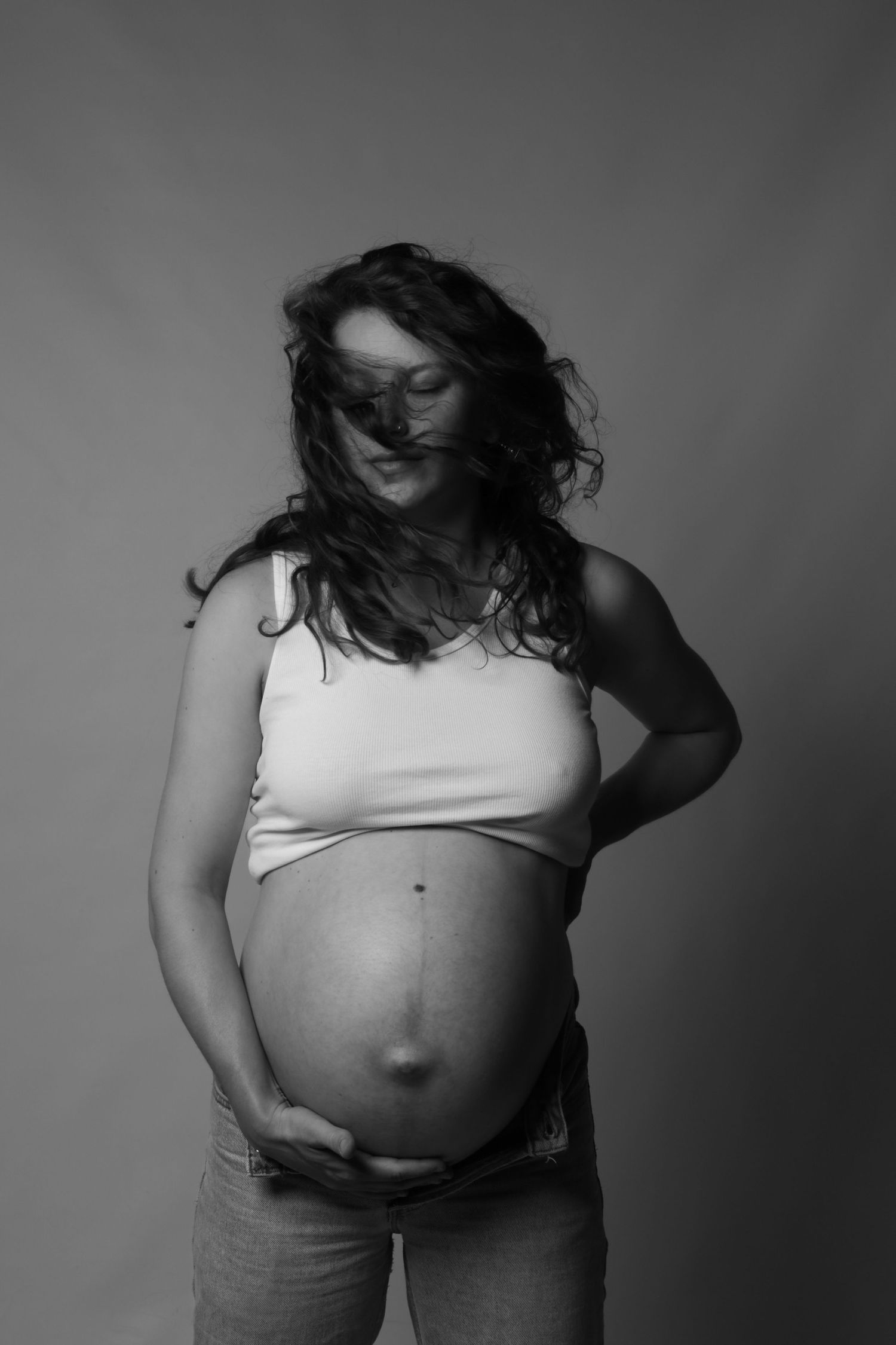 A black and white artistic photo series showing different angles of a person's torso in a white crop top.