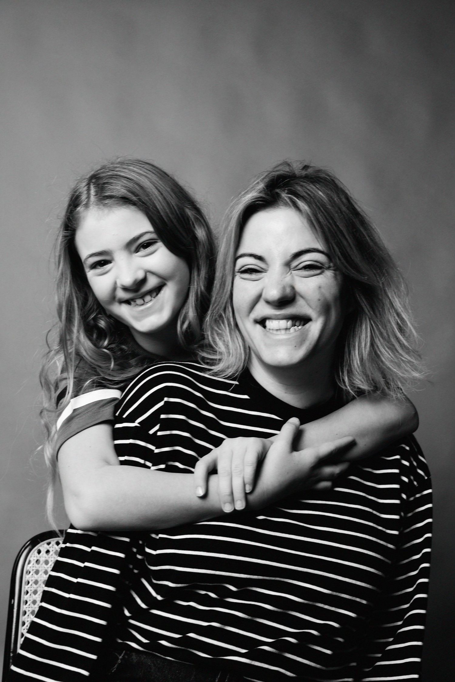 Black and white photo series showing a tender embrace between two people in a striped shirt.