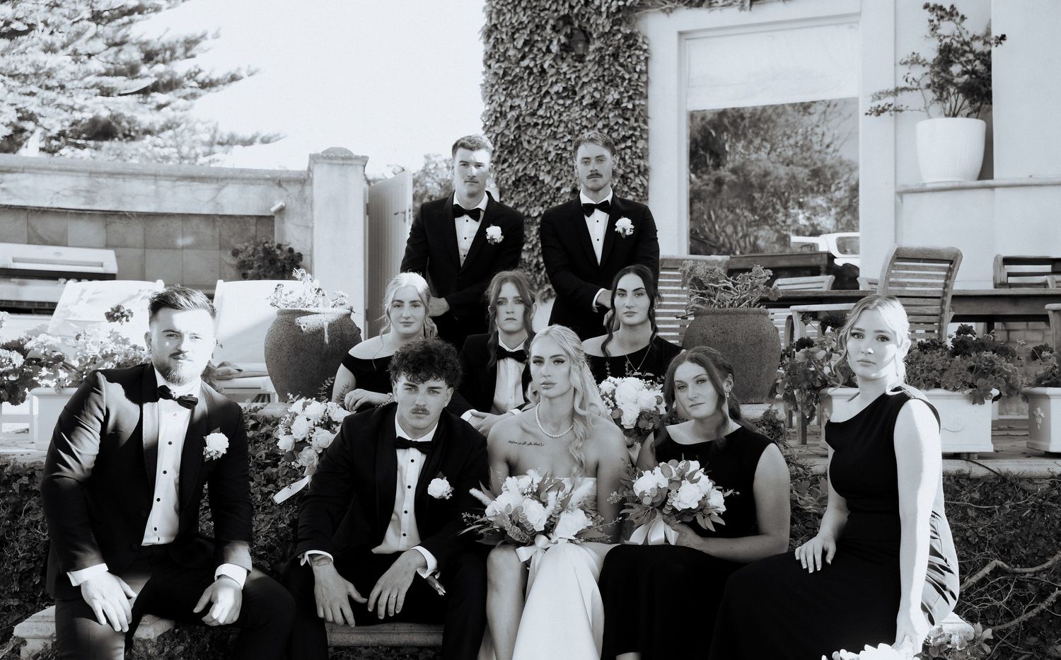 A series of black and white wedding photos showing intimate moments between couples and wedding party members.