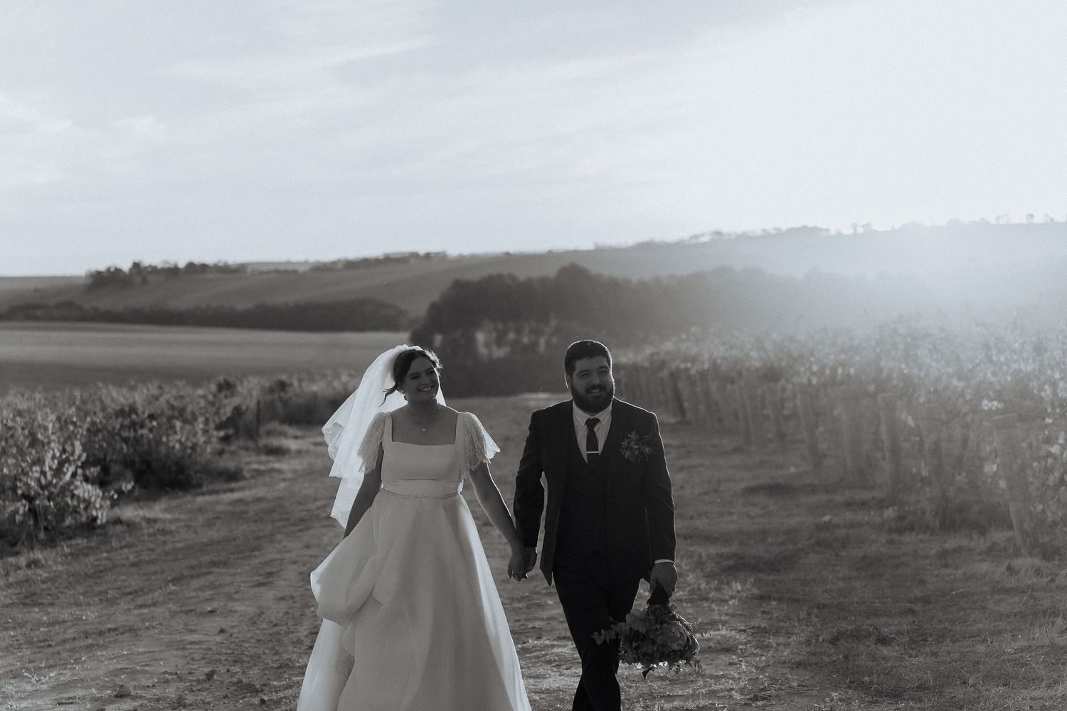 A collection of black and white wedding portraits taken in a misty outdoor field.