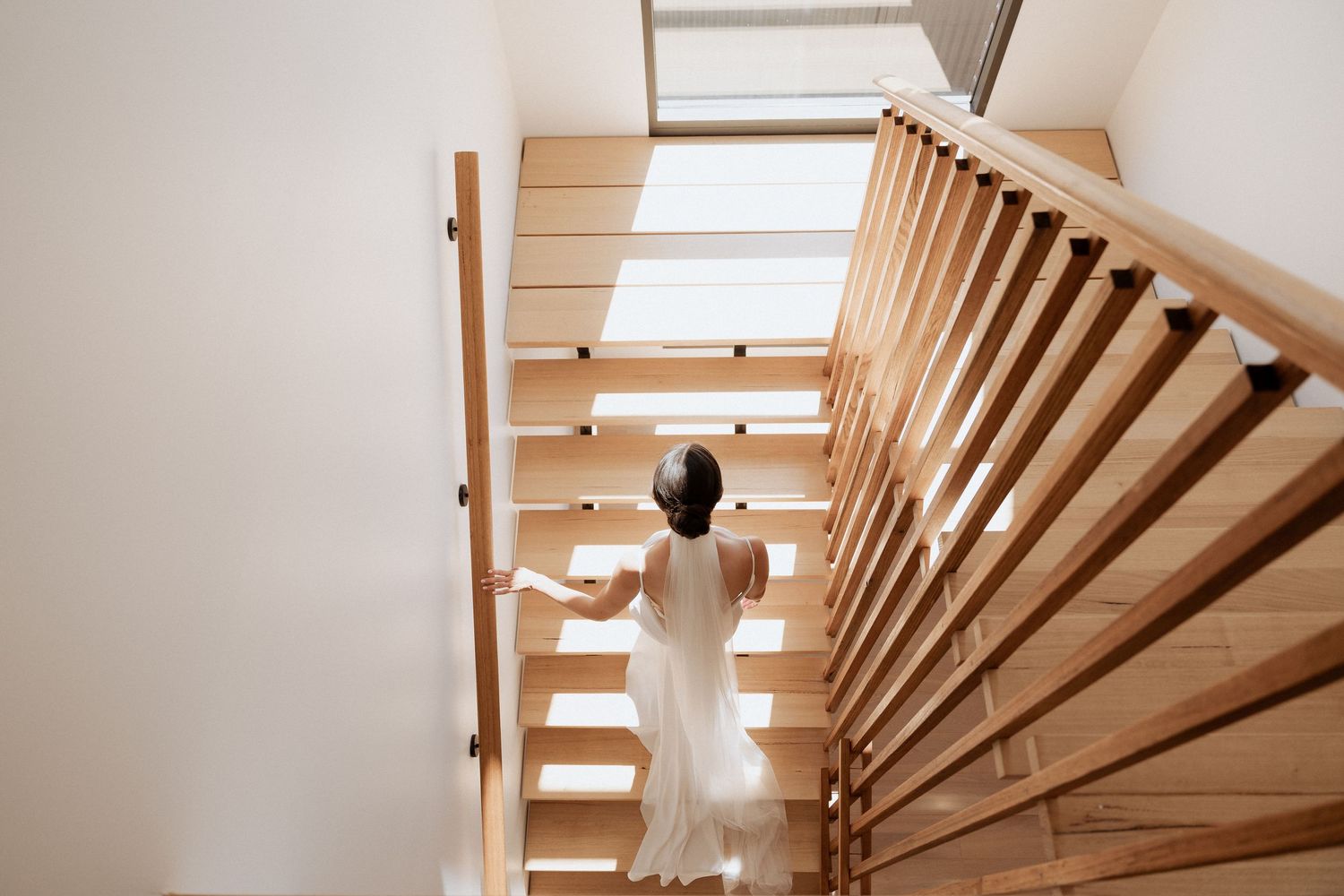 Modern staircase with wooden slats and natural lighting from skylights.