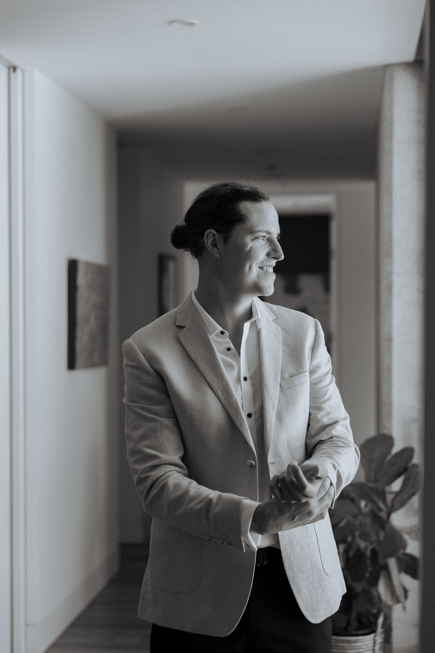 Several timeline photos of someone in a light colored suit jacket in a hallway.