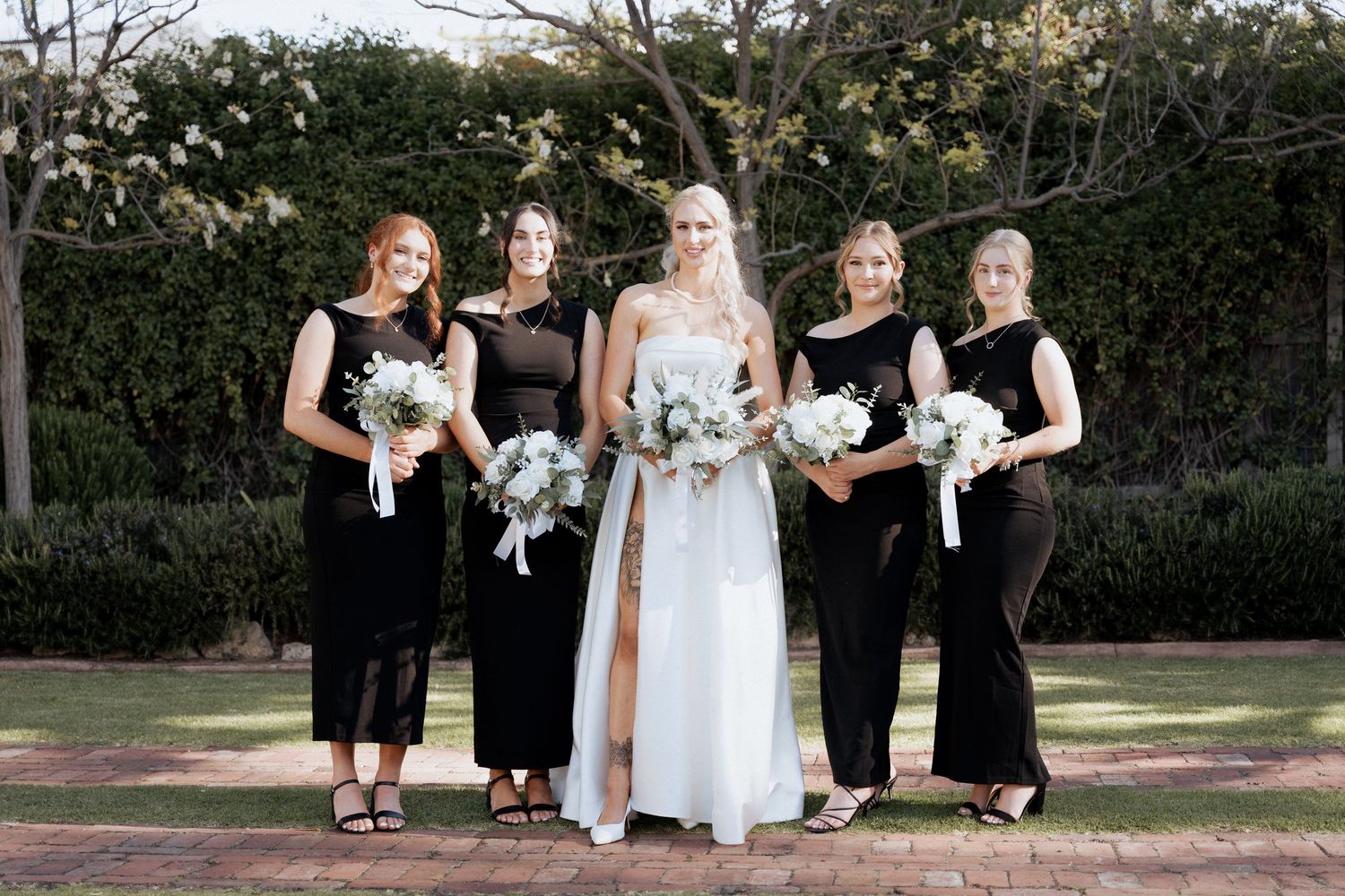 Wedding party poses together on garden grounds in formal attire at the alton house wedding braytmedia