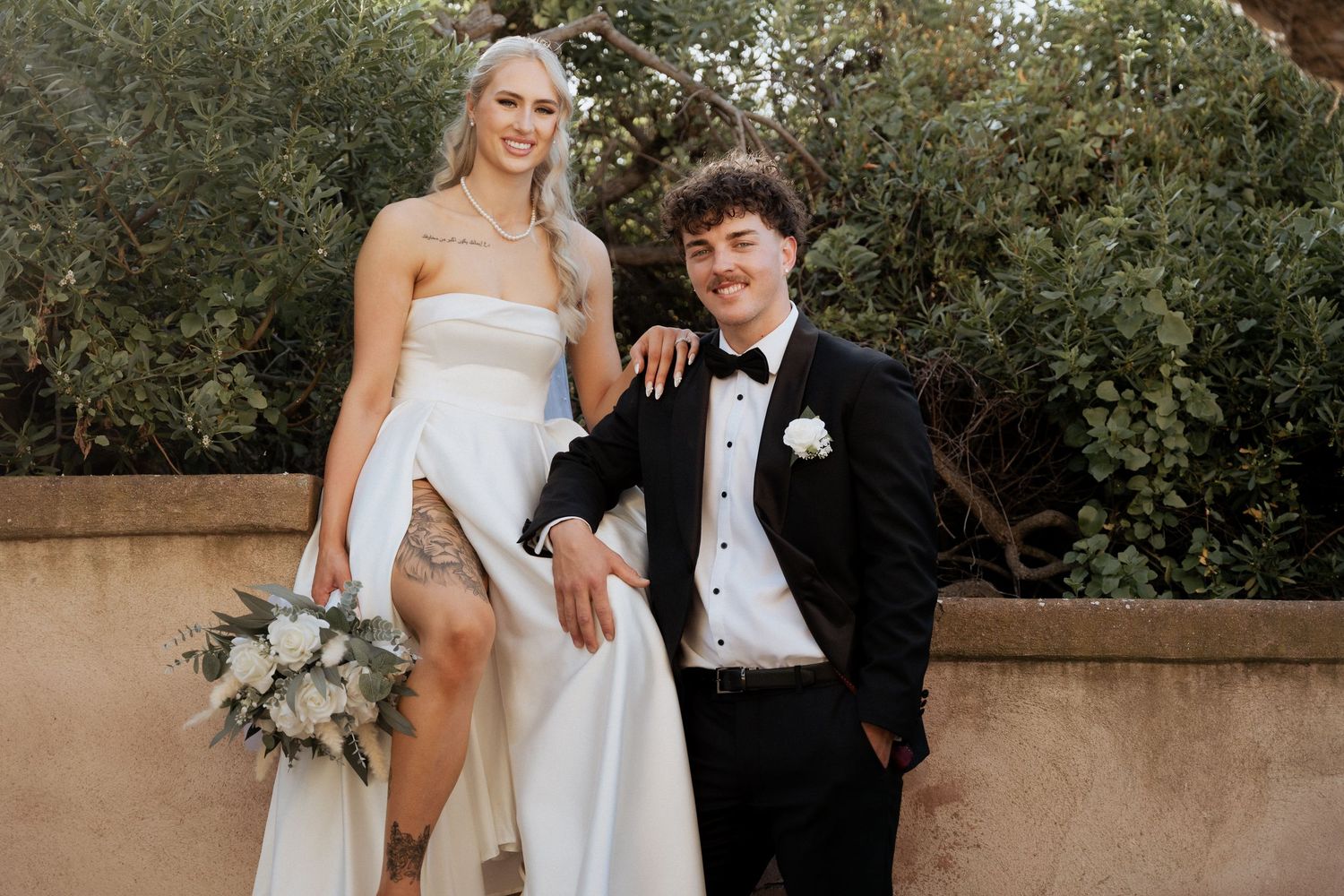 Wedding couple posing together on a sunny terrace with white floral bouquet at the alton house, images by braytmedia