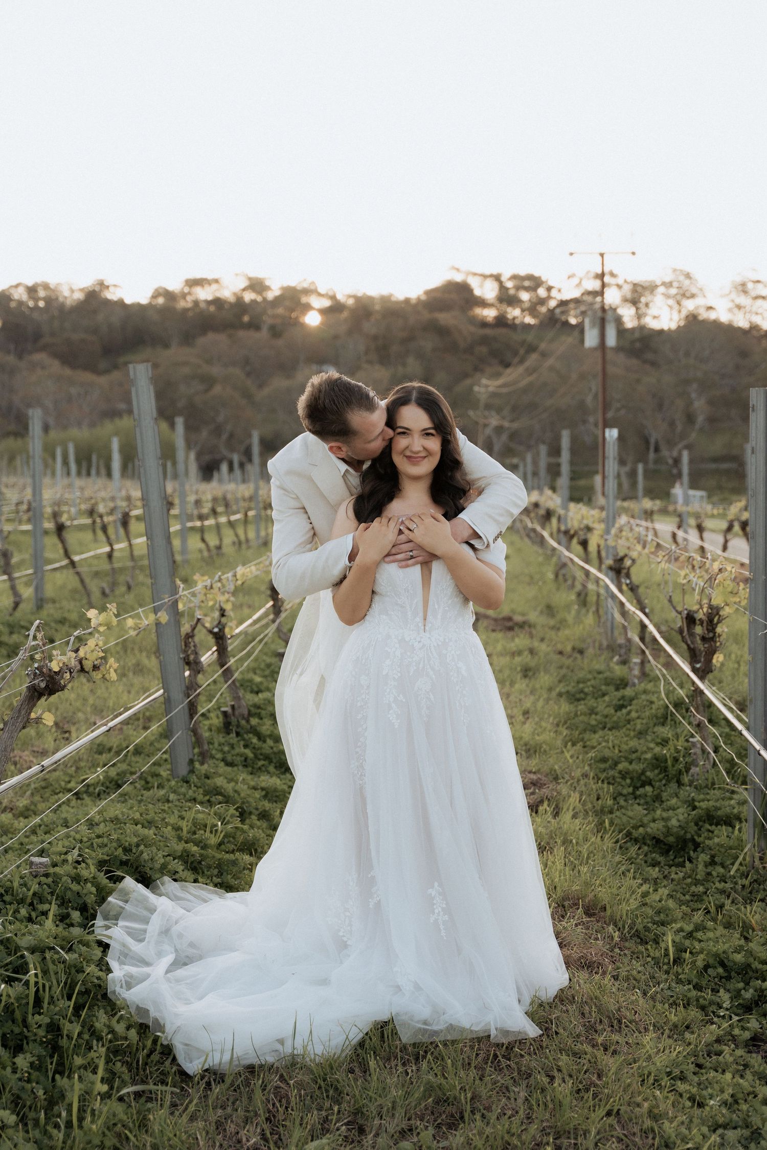 Romantic sunset photos of newlyweds among the vineyard rows during golden hour at Howard vineyard Captured by Braytmedia