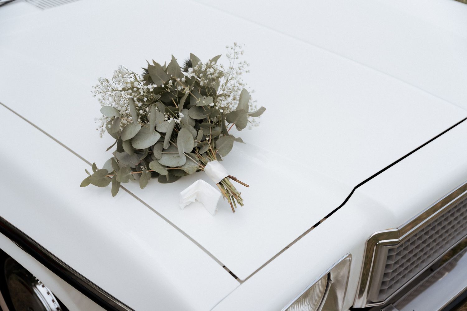 Minimal white wedding album layout with dried floral elements.