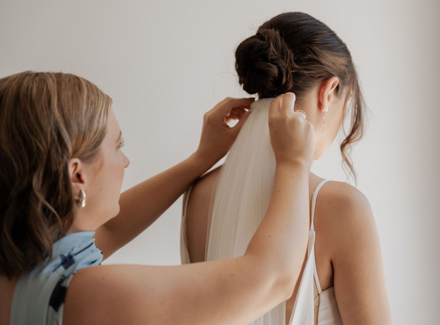 Close-up of bridal preparations with white dress details.