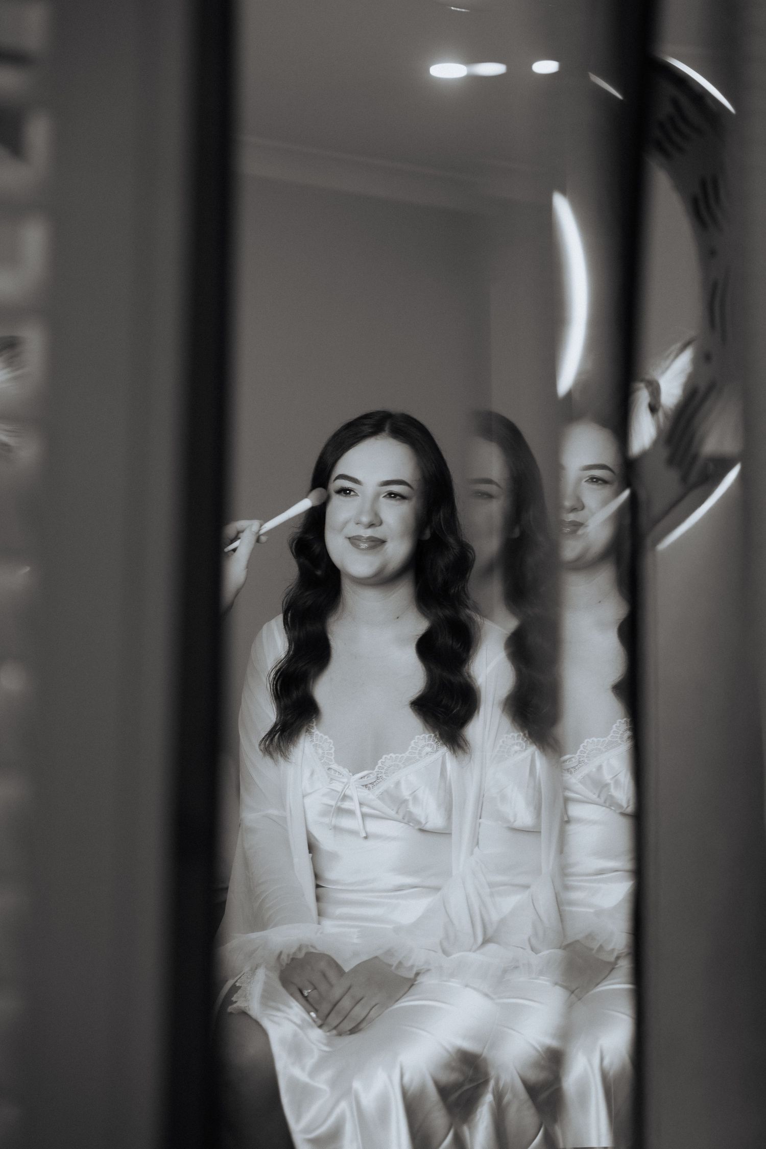 A black and white artistic portrait shows a figure in white clothing with reflections creating a dreamy, ethereal effect.