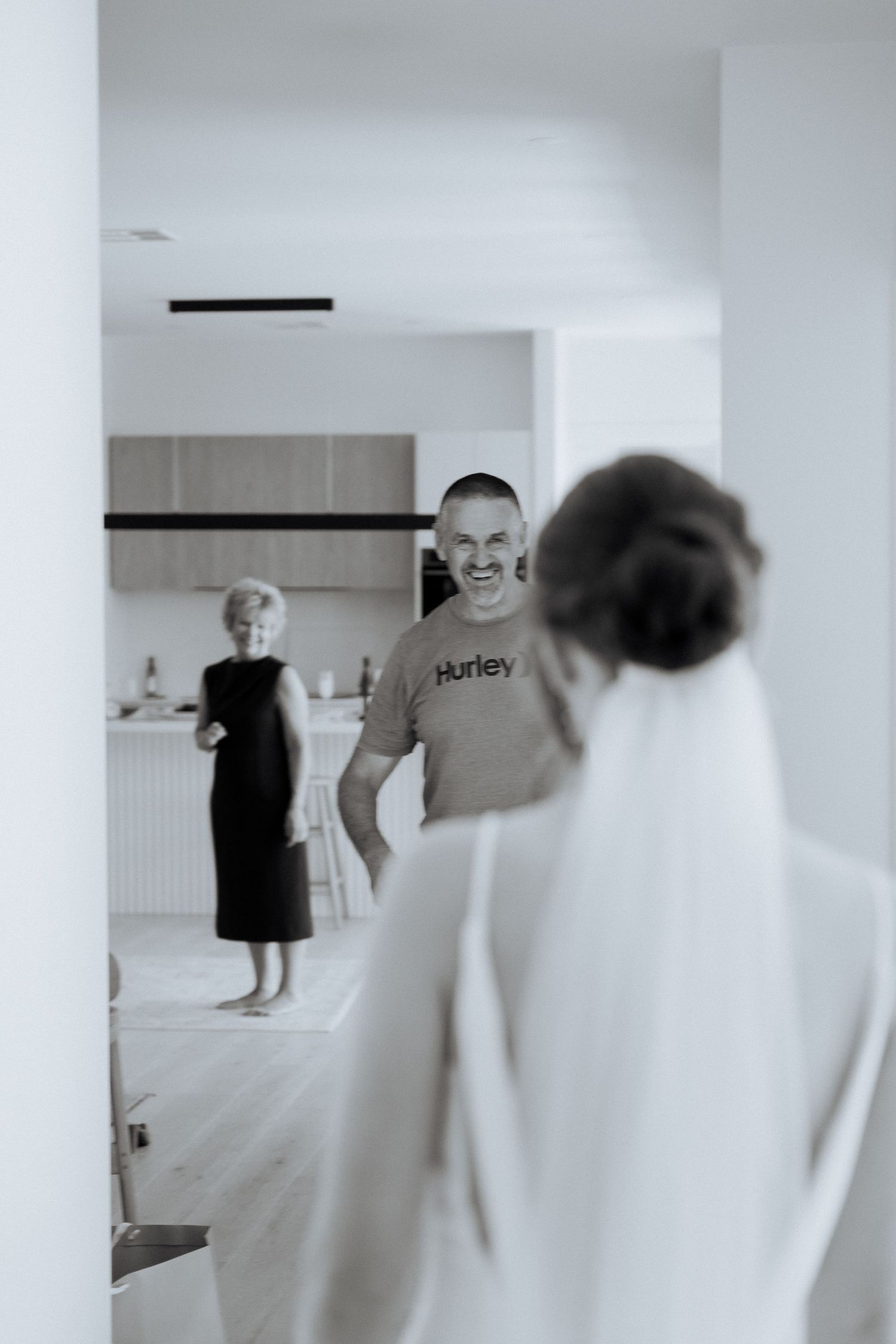 A black and white candid moment captured in a modern kitchen setting.
