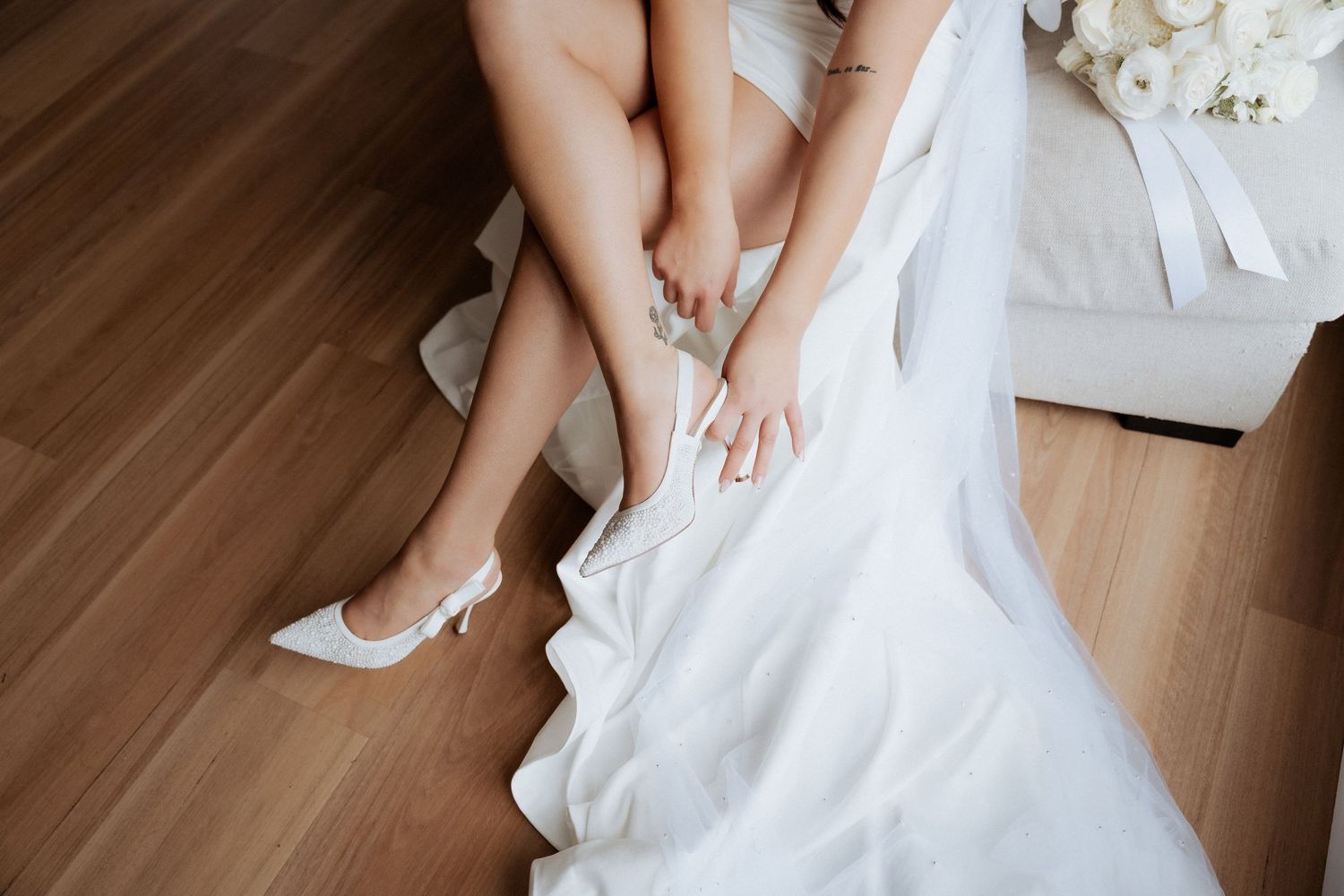 Detail shot of wedding dress fabric and lace on wooden flooring. Lot100 wedding venue images by Braytmedia. Adelaide