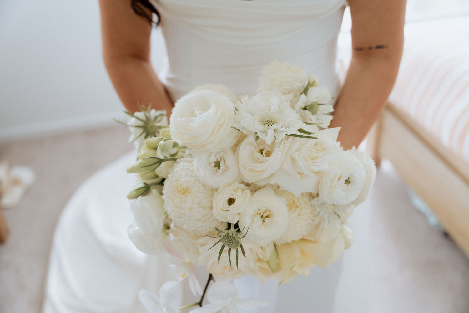Elegant white bridal bouquet featuring roses and orchids against a light background. Lot100 wedding venue images by Braytmedia. Adelaide